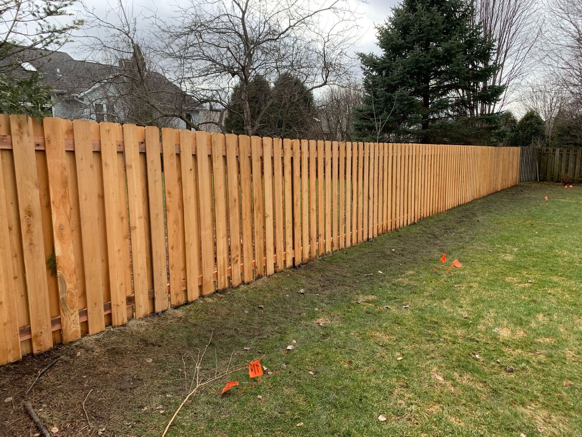 A wooden fence is sitting in the middle of a lush green yard.