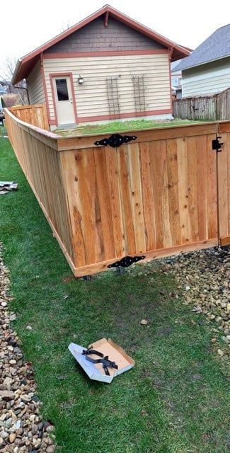 A wooden fence is being built in front of a house.