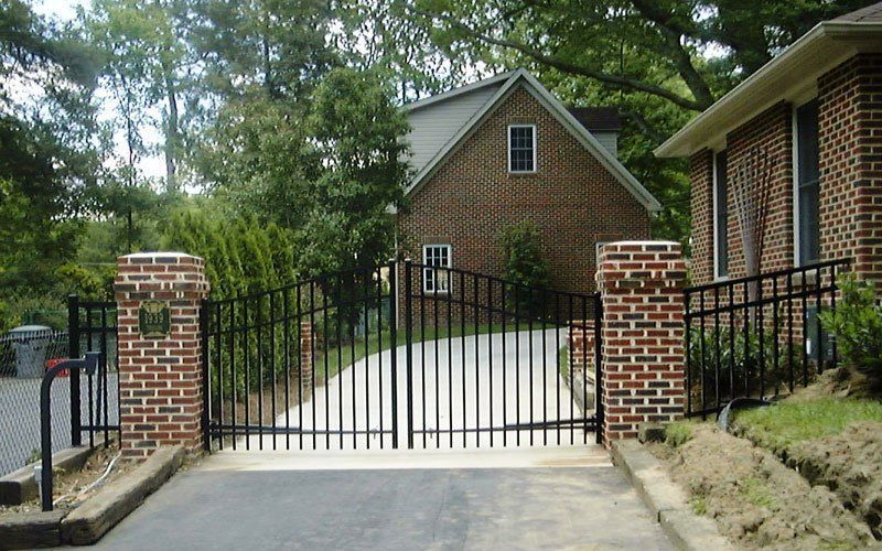 A brick house with a black gate in front of it