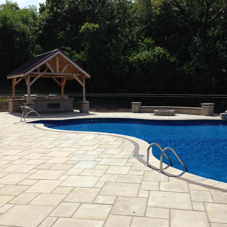 A large swimming pool with a gazebo in the background