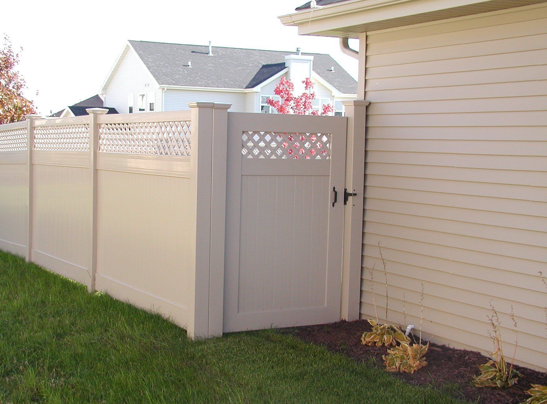 A white fence with a gate in front of a house