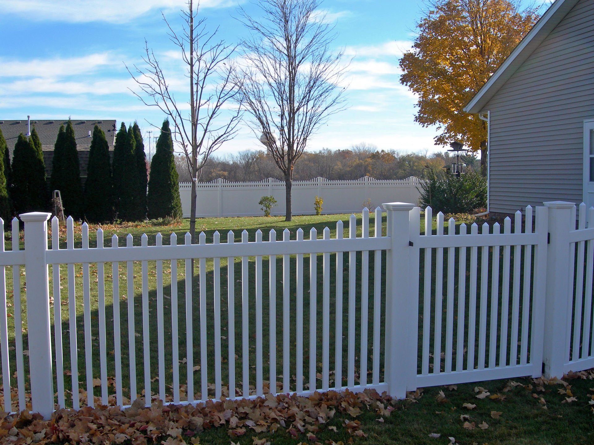 A white picket fence in front of a house