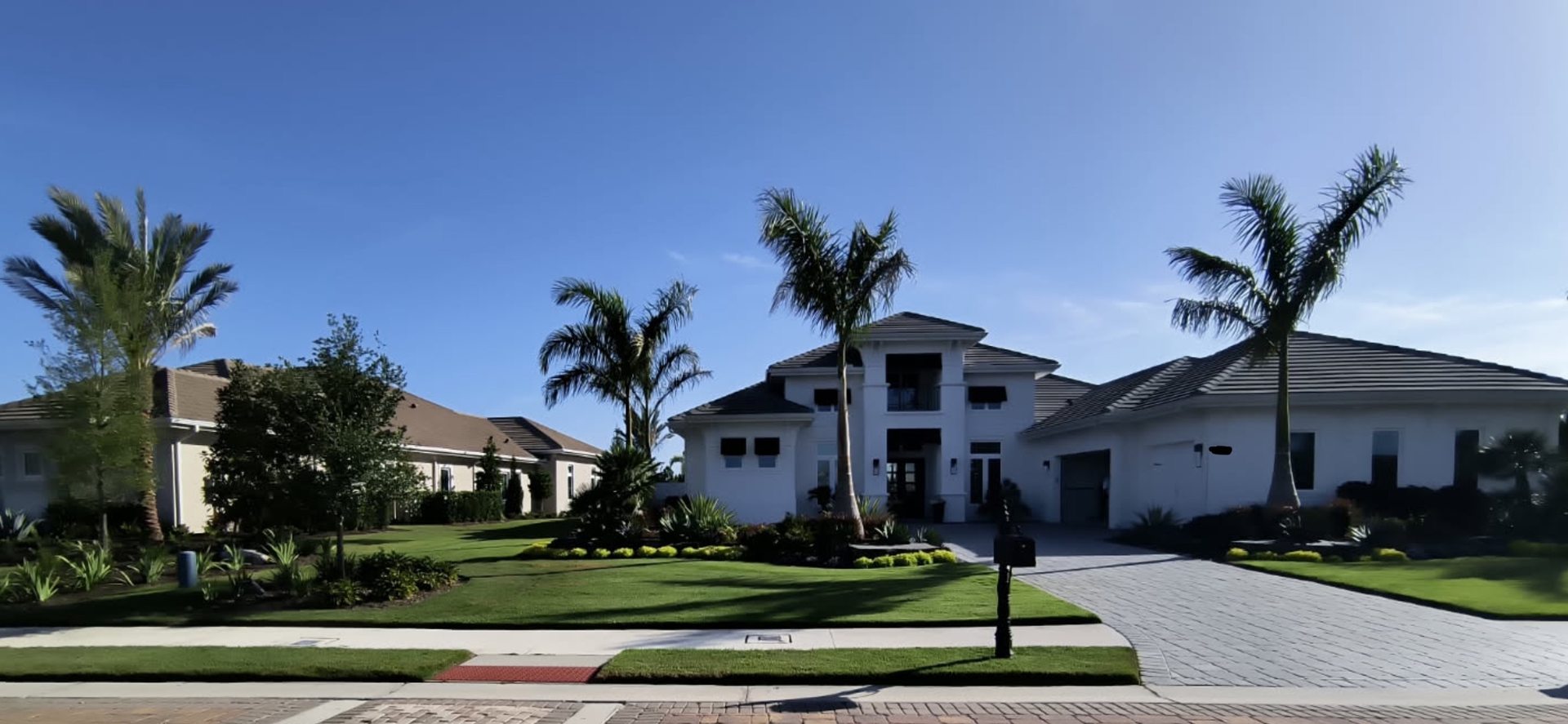 A large white house with palm trees in front of it