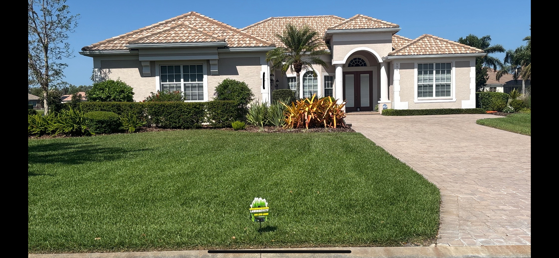 A large white house with a lush green lawn in front of it.