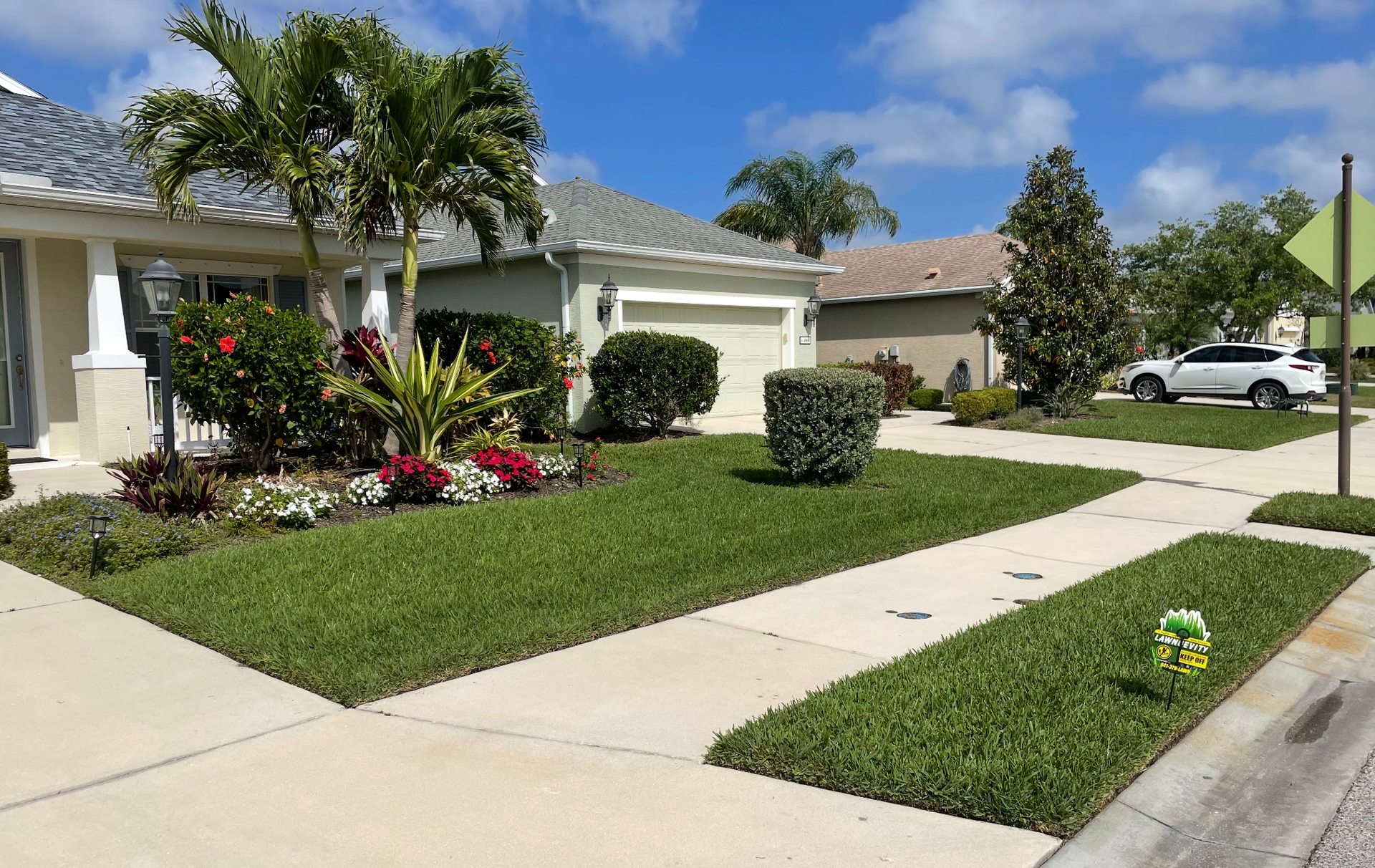 A soccer ball is sitting on the sidewalk in front of a house.
