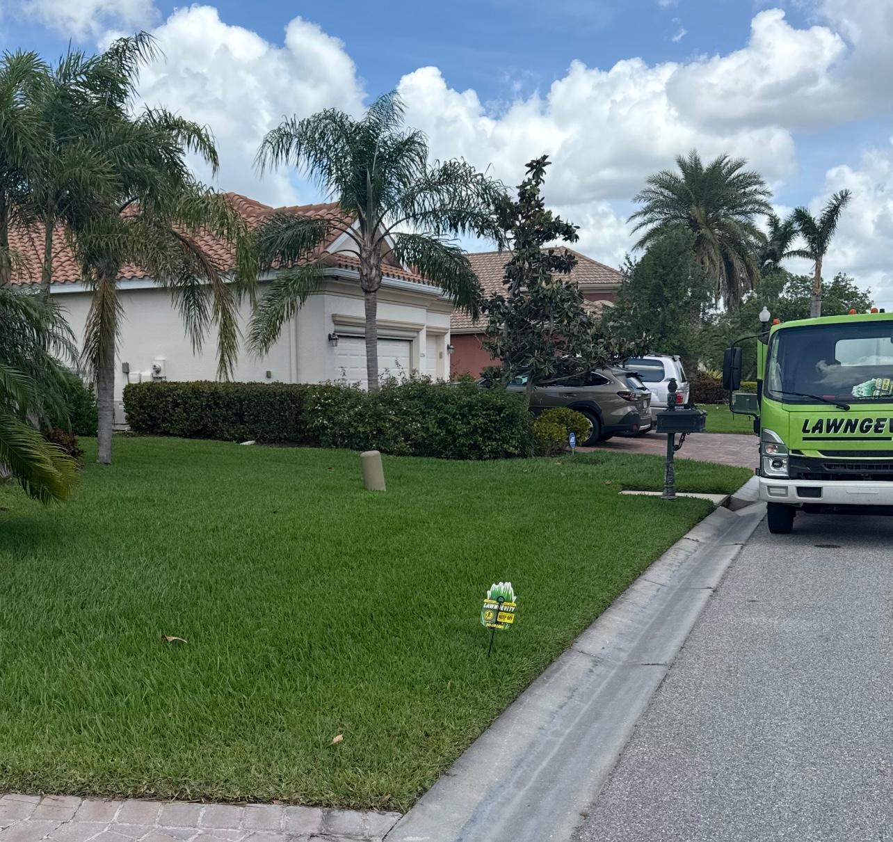 A green carwise truck is parked on the side of the road
