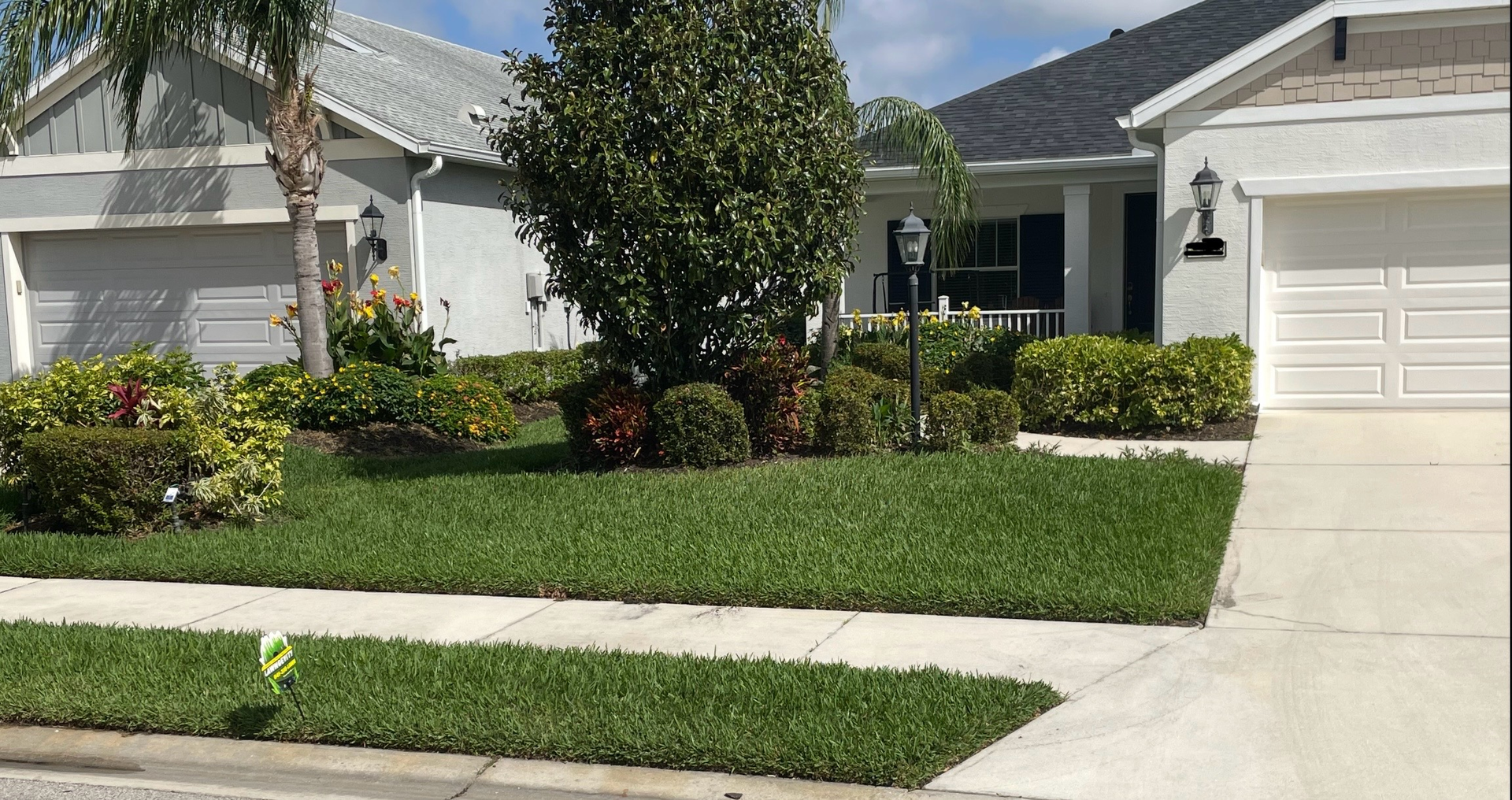 A white house with a lush green lawn in front of it.