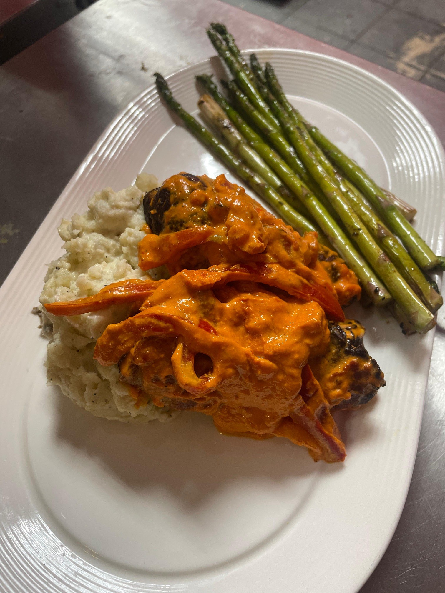 Plate with chicken in orange sauce, rice, and asparagus.