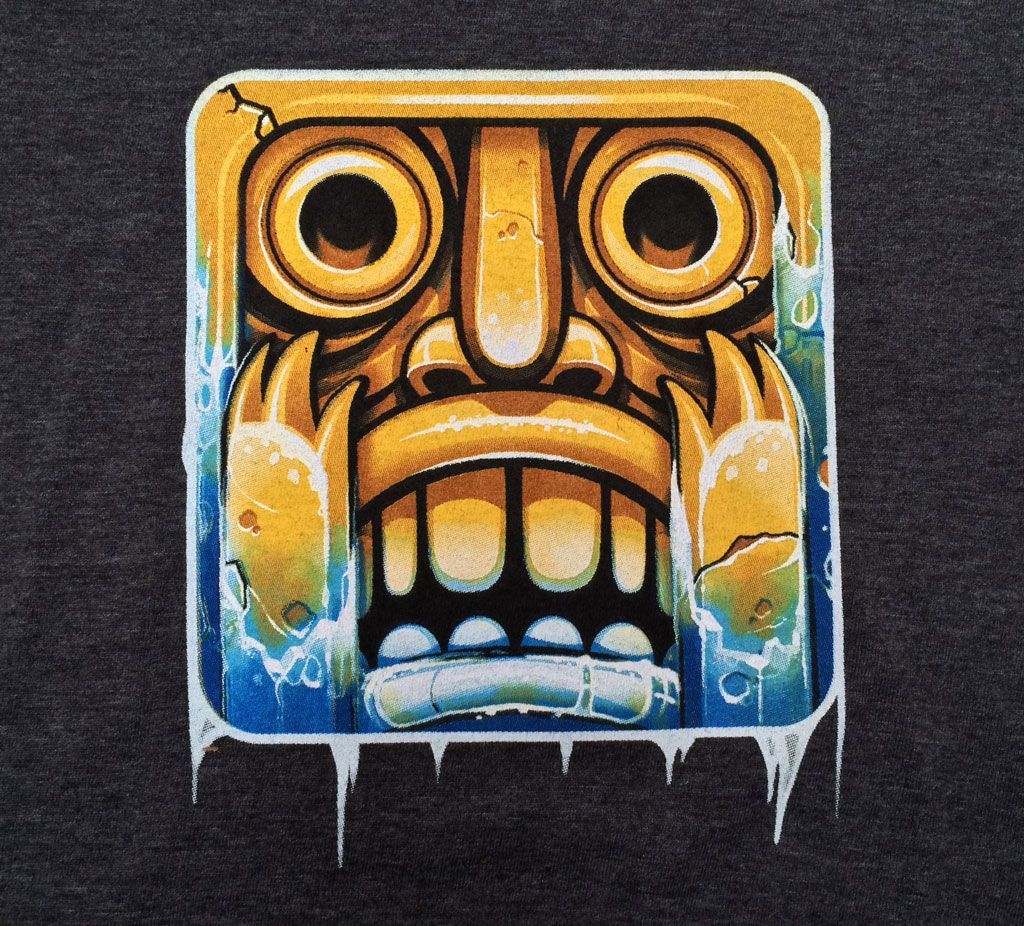 A golden, carved totem mask with a wide-eyed expression, depicted with icy blue accents and drips against a dark background.