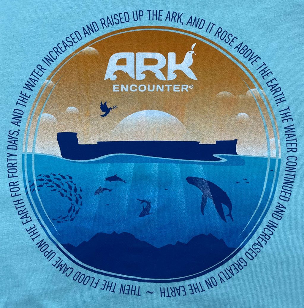 Graphic of the Ark Encounter logo, a dark silhouette of an ark on water, sea life below, and circular text on a blue shirt.