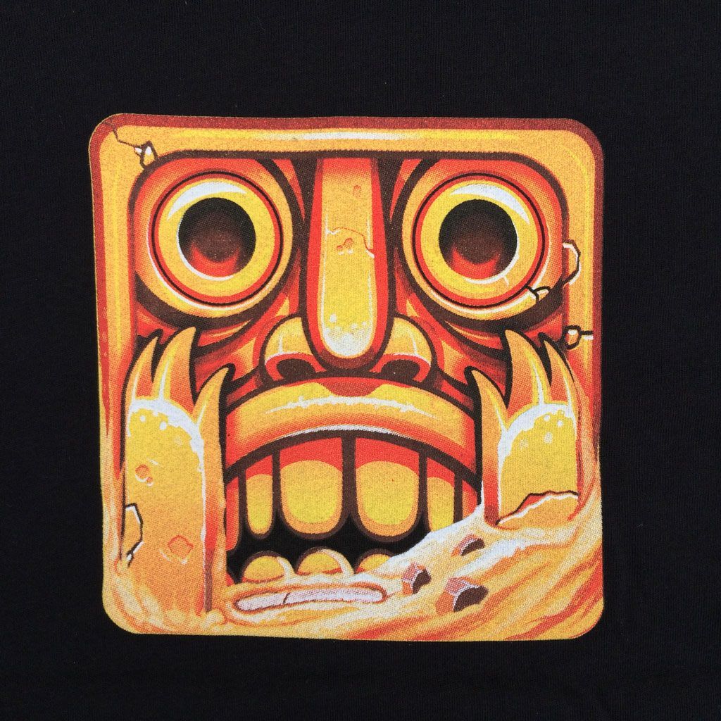 A square, gold-colored stone idol from the game Temple Run, featuring large eyes, a wide mouth, and a weathered texture.