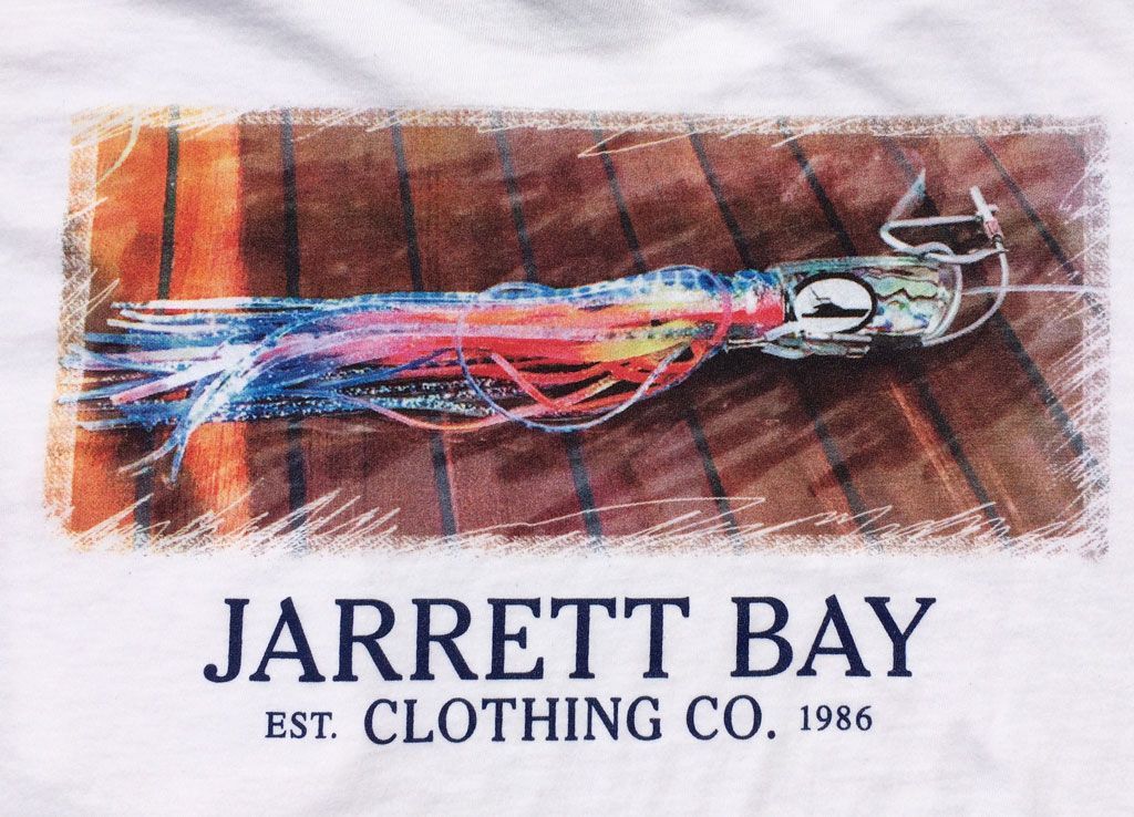 A colorful fishing lure rests on a wooden deck above the text 