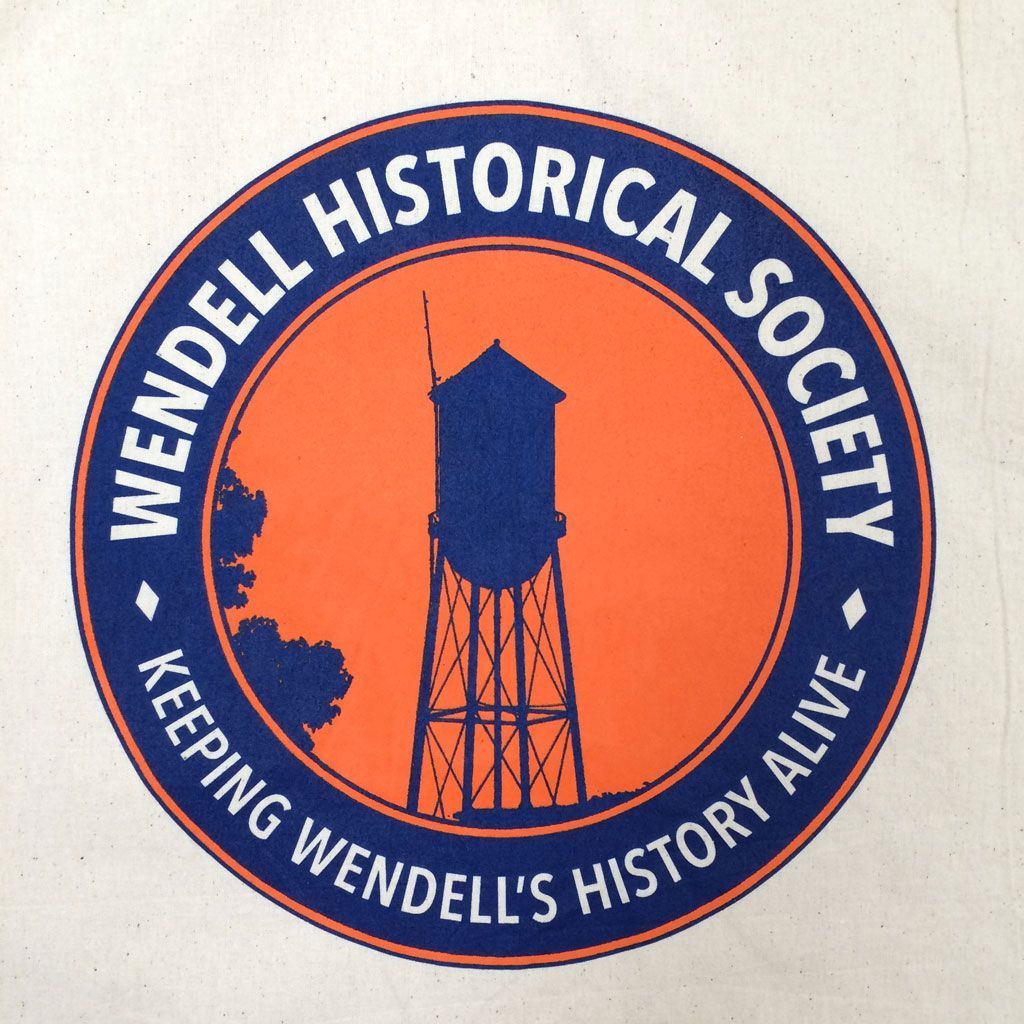 Circular logo for the Wendell Historical Society, featuring a dark blue water tower silhouette on an orange background.