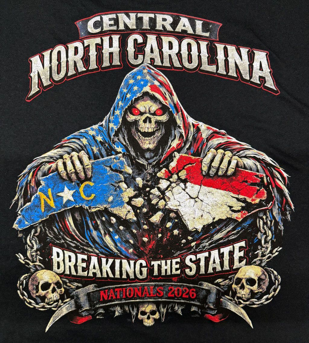 A skull in a US flag hood rips the North Carolina flag in two, with the text 