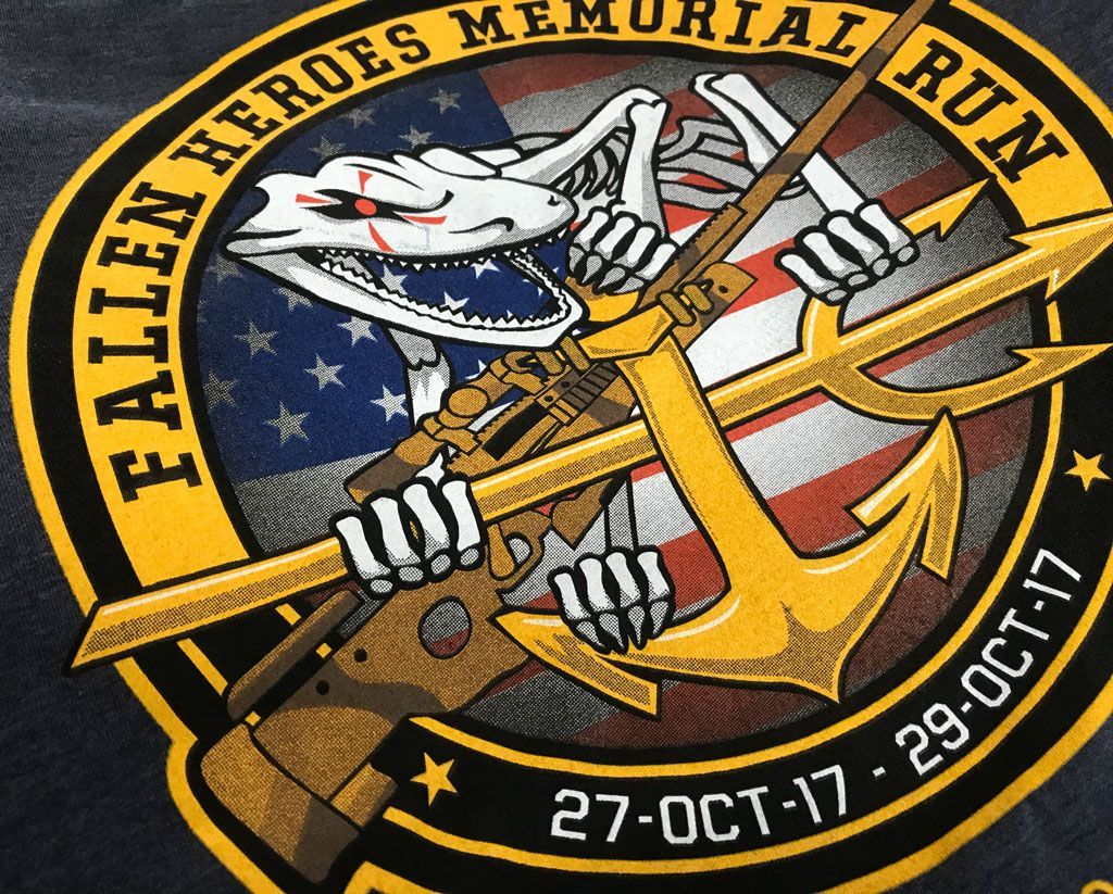 A circular patch depicting a skeletal creature holding a rifle and gold anchor over an American flag, reading 2017 dates.