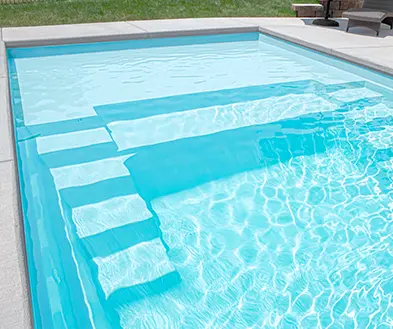 Blue swimming pool with stepped shallow ledge and clear water
