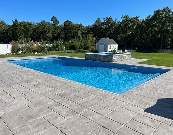A large swimming pool with a small house in the background
