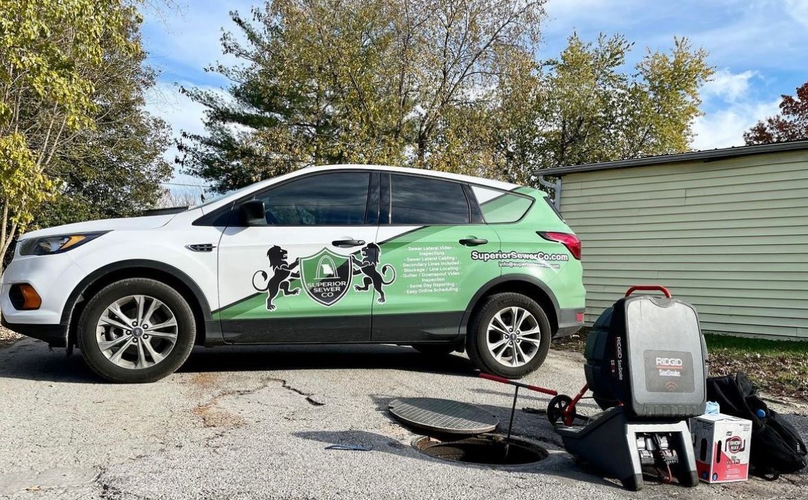 White SUV with company logo parked outside; equipment and supplies nearby.