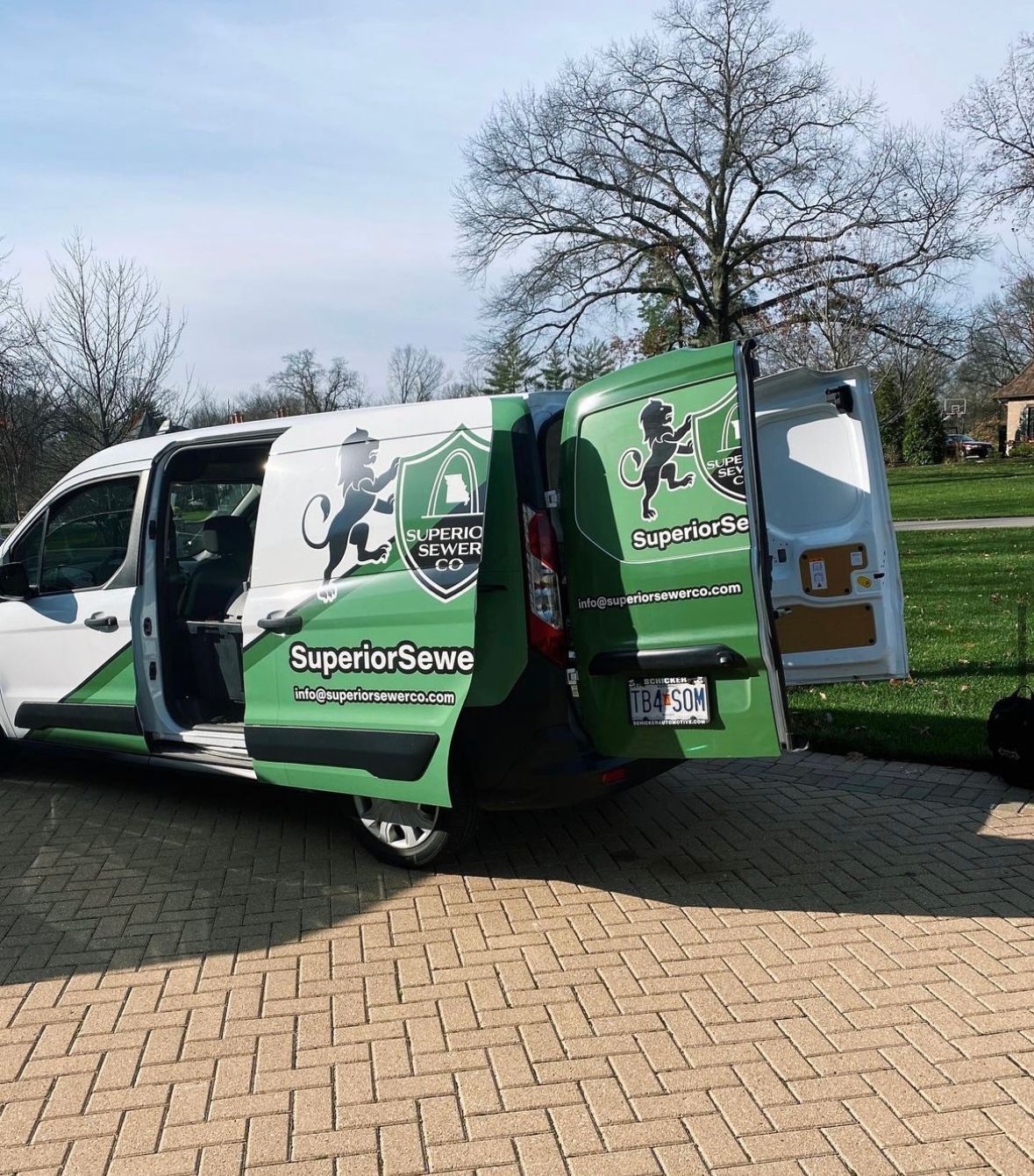 A white and green service van with open doors; logo reads 