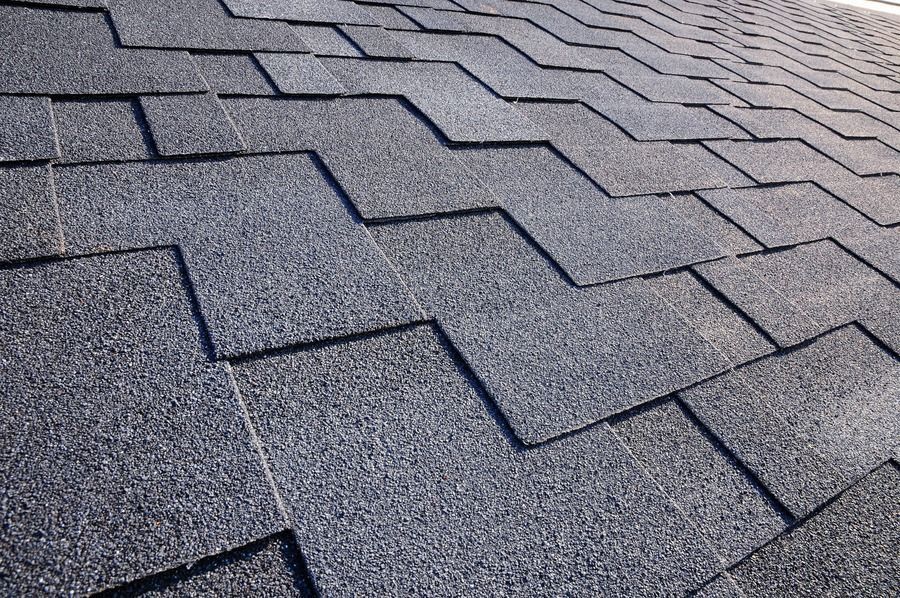 Gray asphalt roof shingles in a close-up pattern