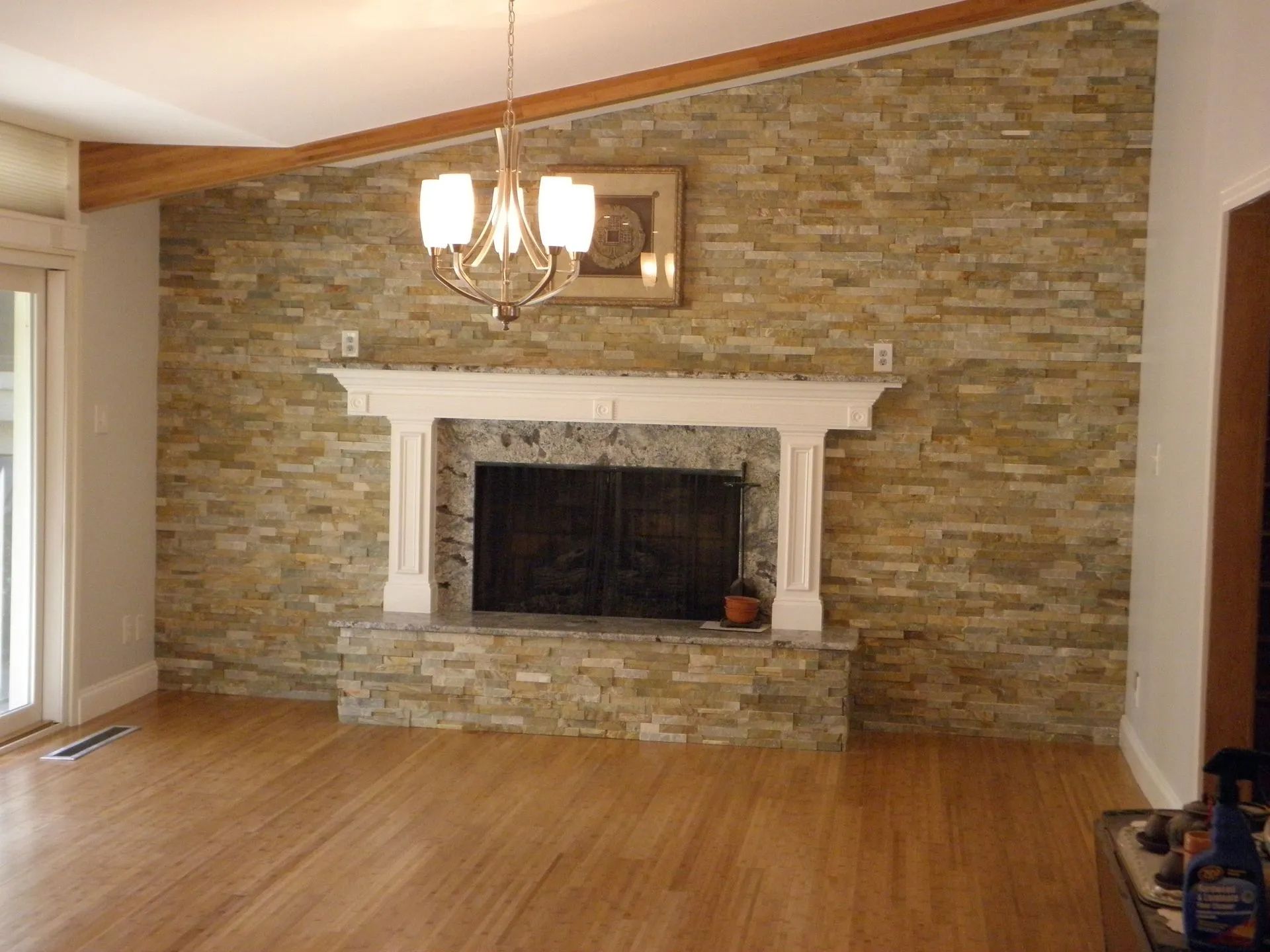 A living room with a fireplace and a stone wall