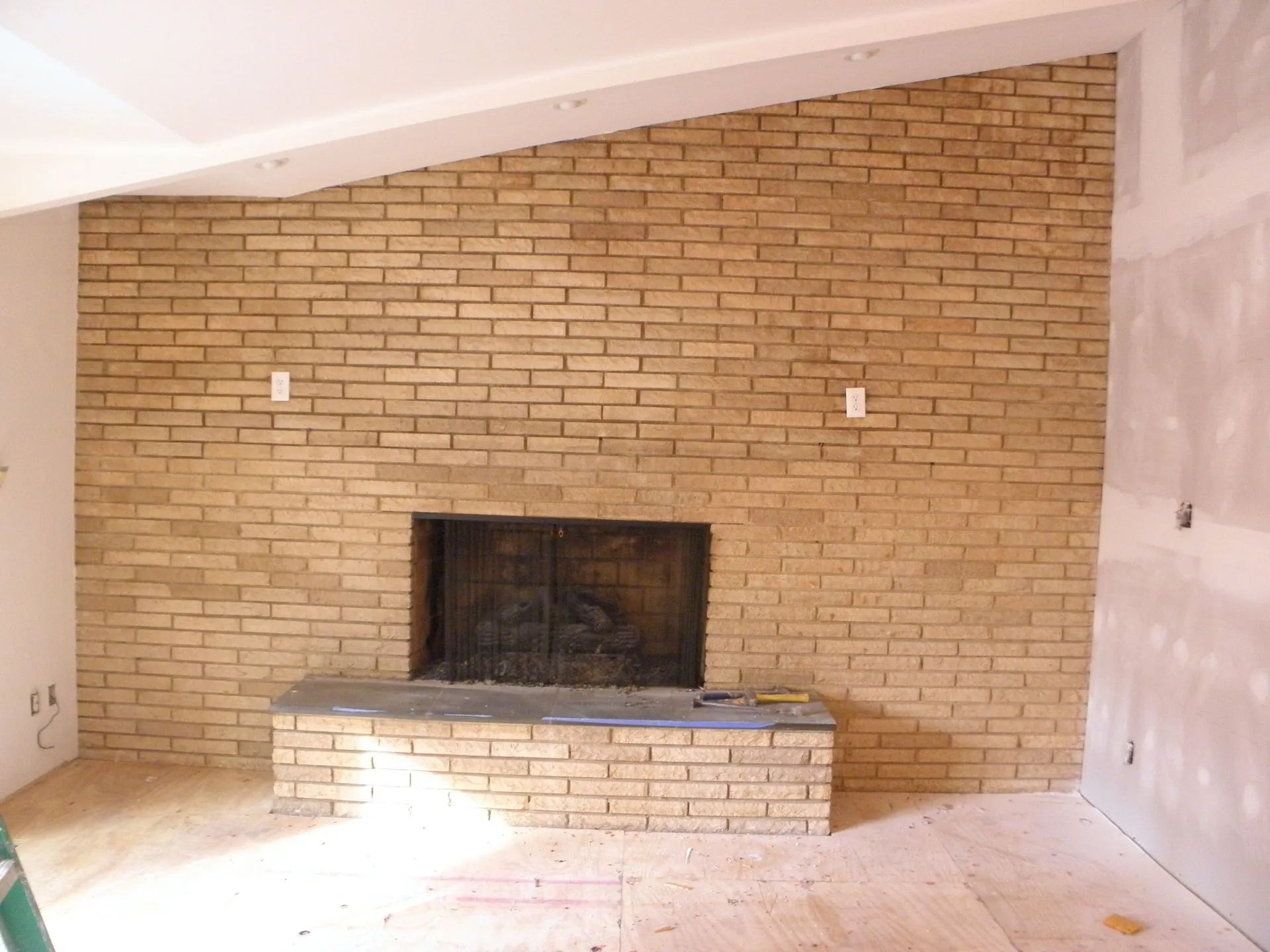 A brick wall with a fireplace in the middle of it