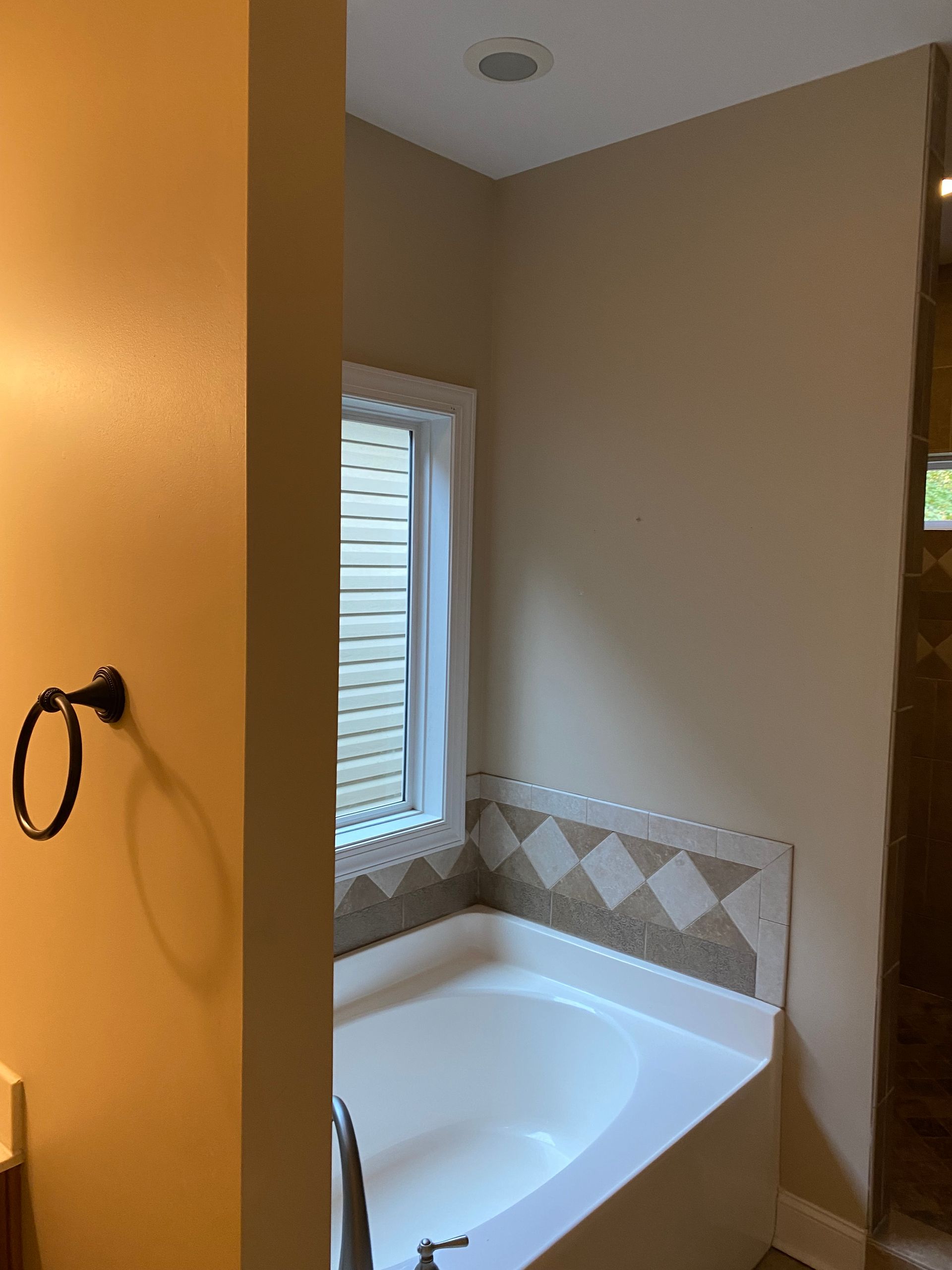A bathroom with a bathtub and a window.