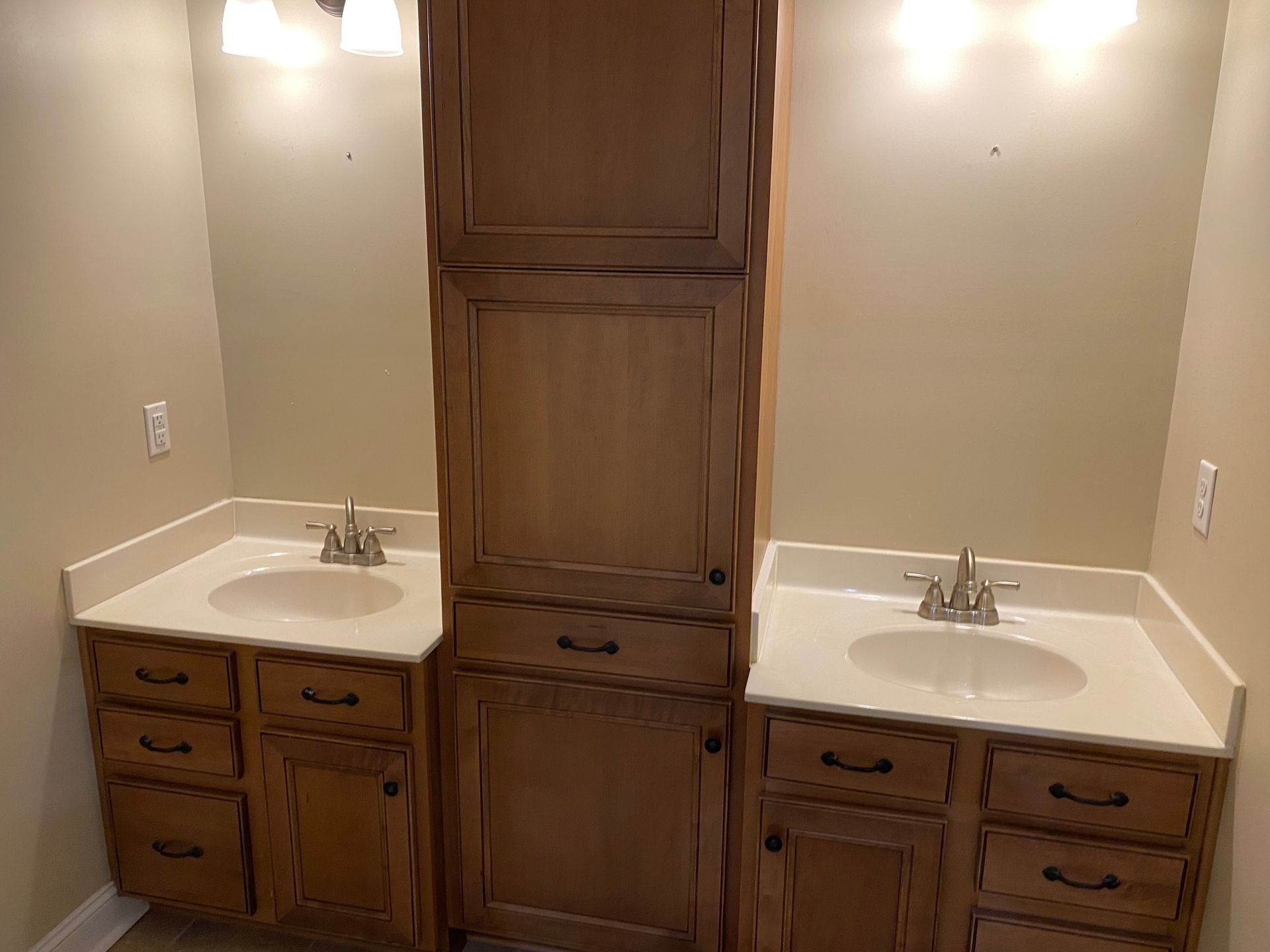 A bathroom with two sinks and a cabinet.