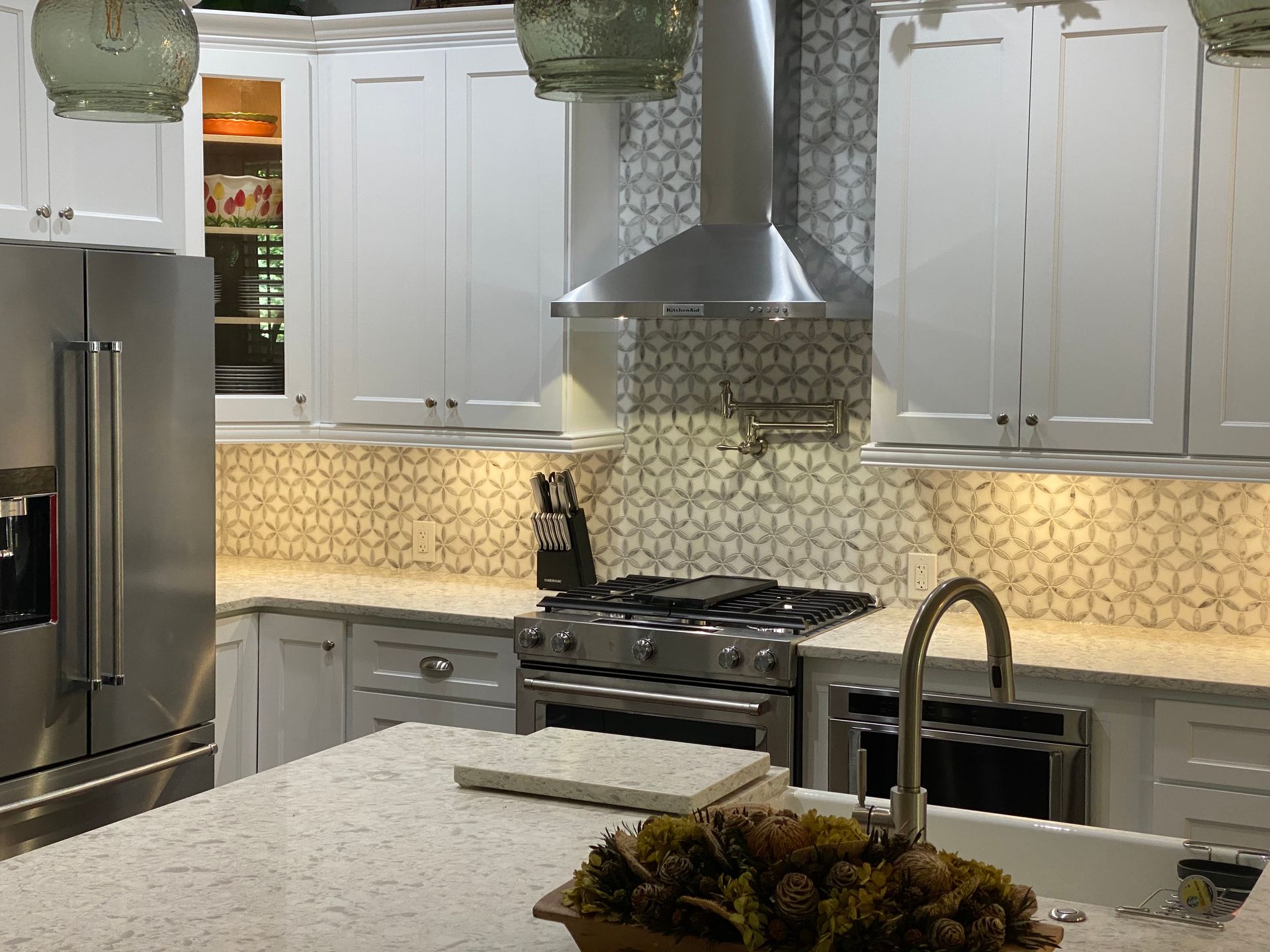 A kitchen with white cabinets and stainless steel appliances