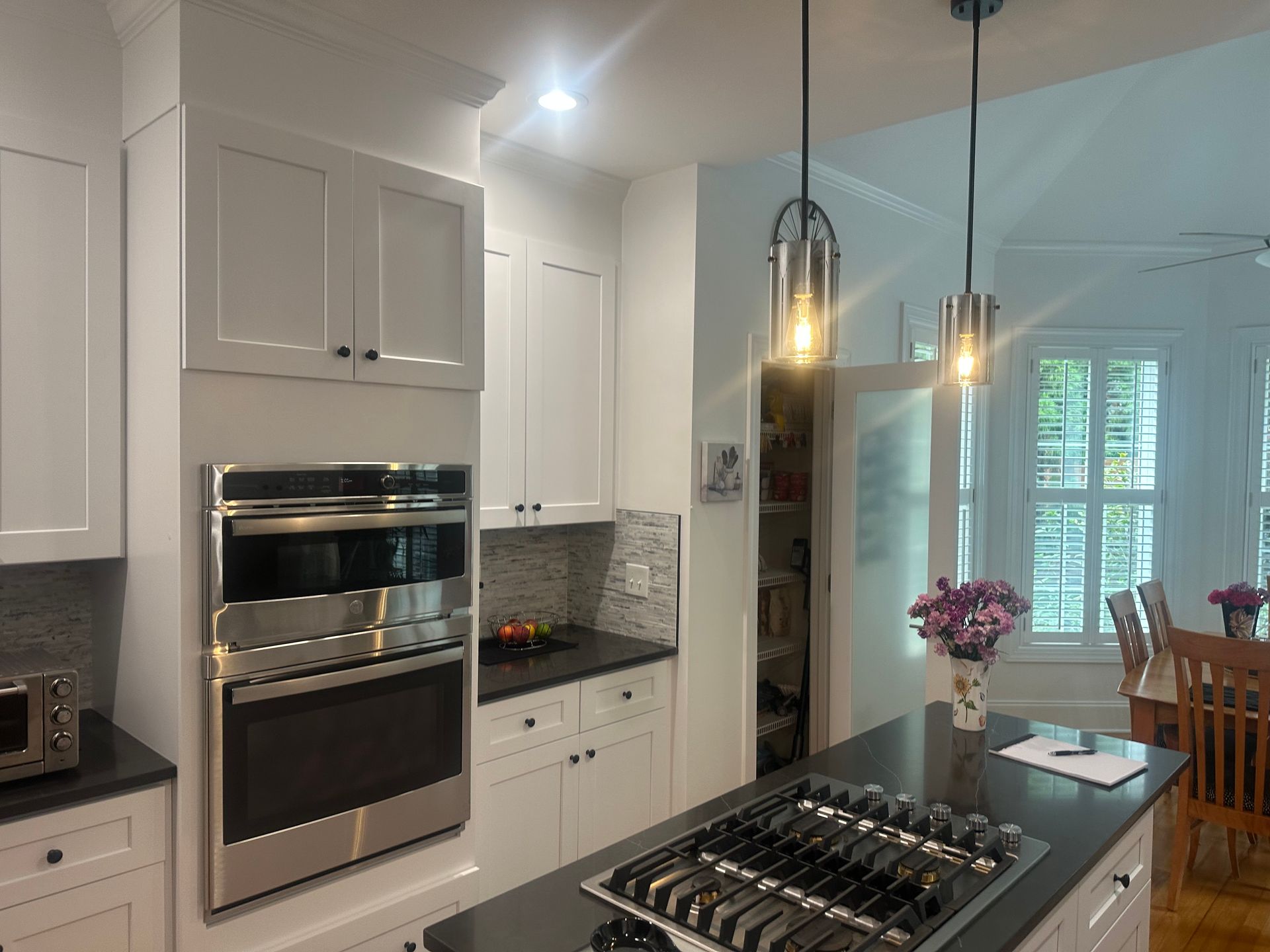 A kitchen with white cabinets and stainless steel appliances