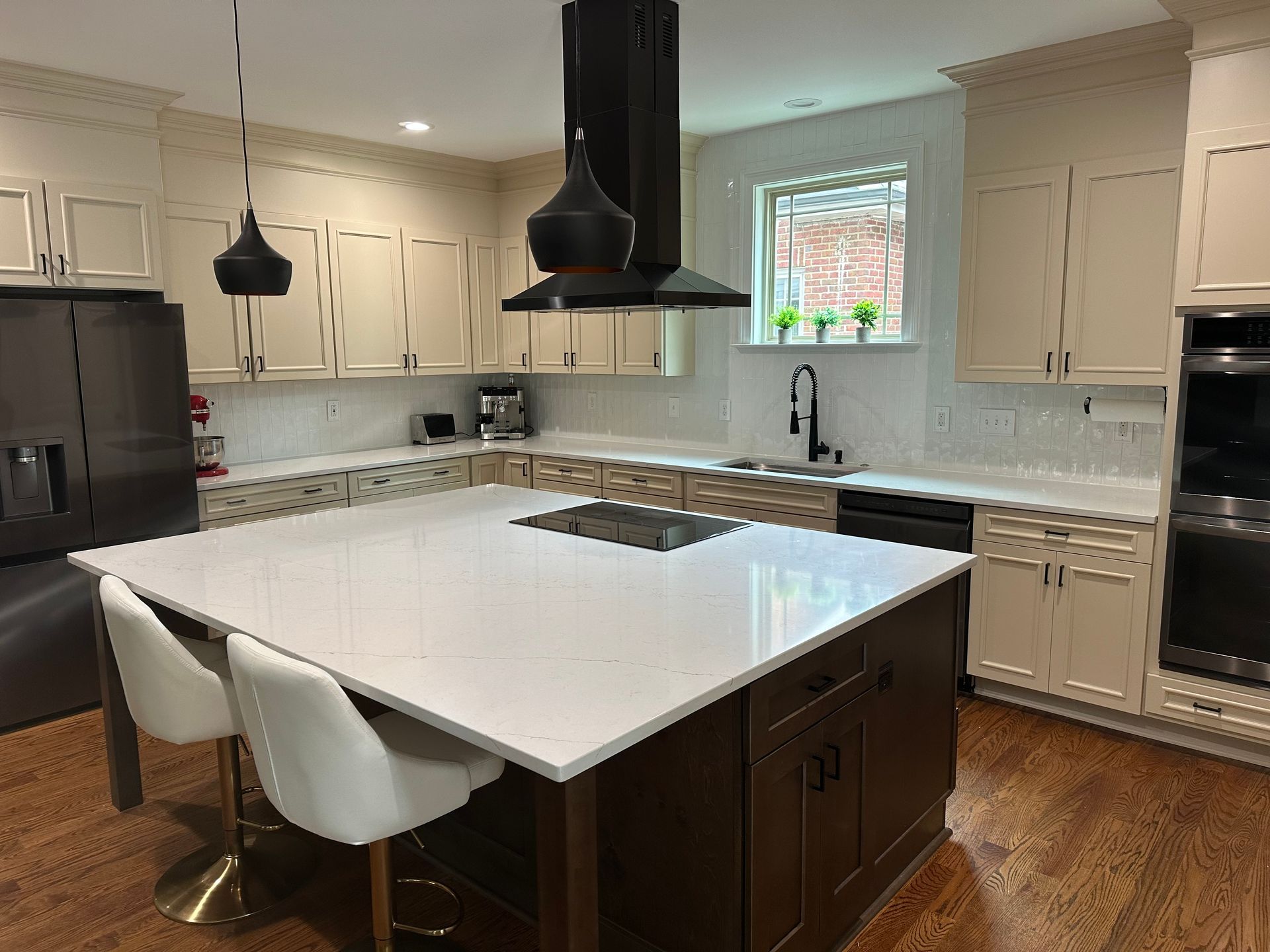 A kitchen with a large island and white counter tops.
