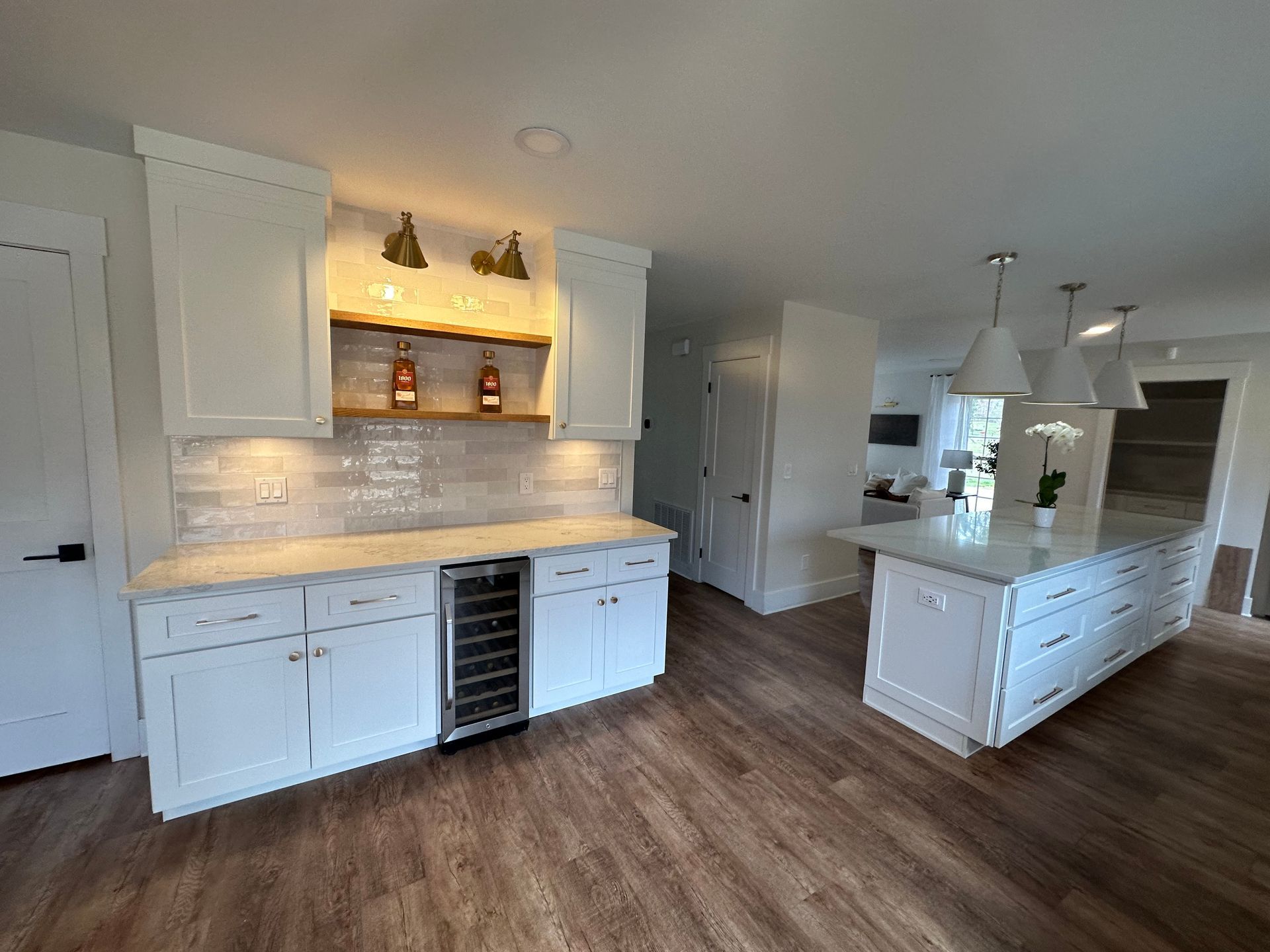 A kitchen with white cabinets and a wine cooler.