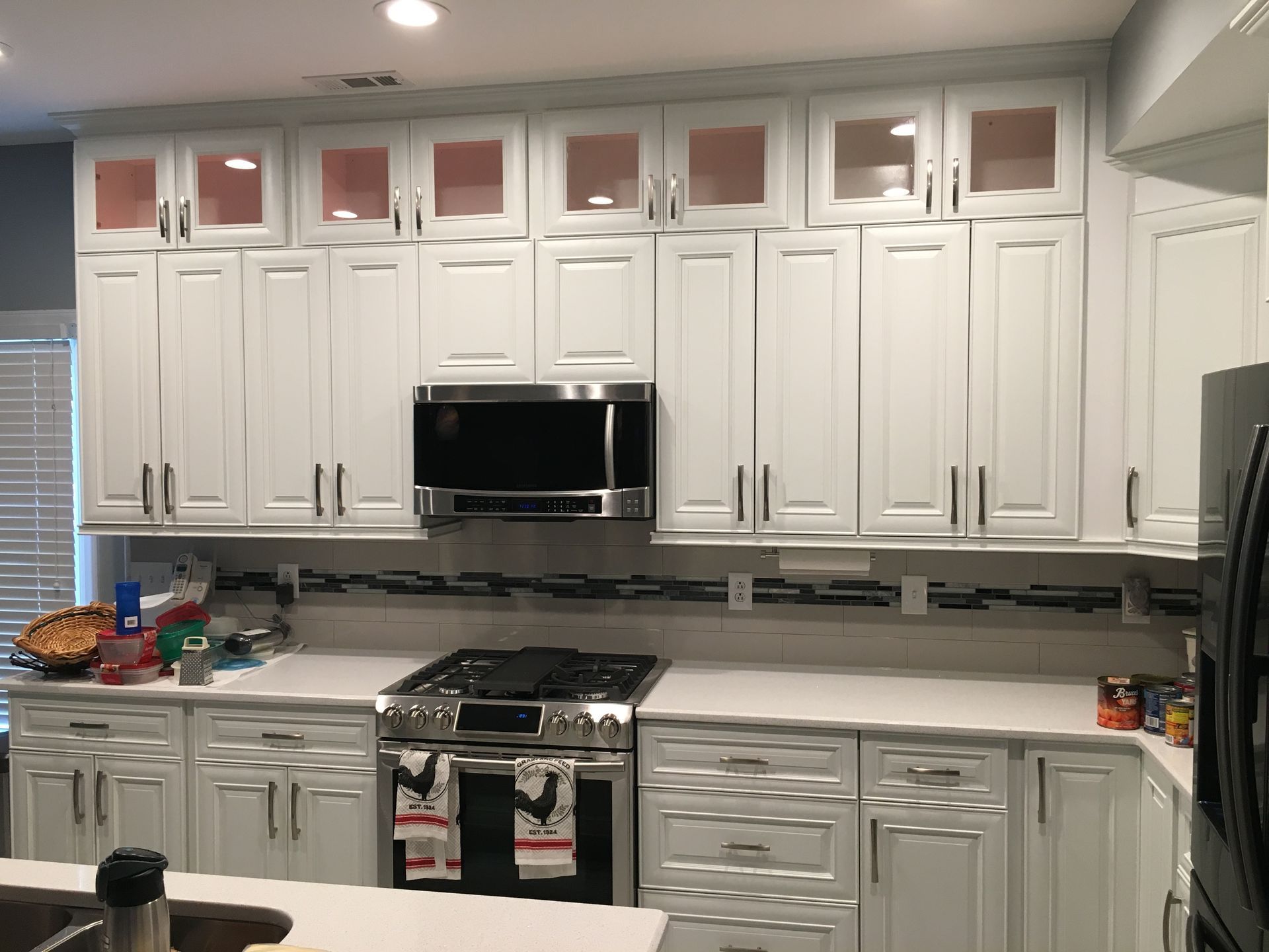 A kitchen with white cabinets and stainless steel appliances