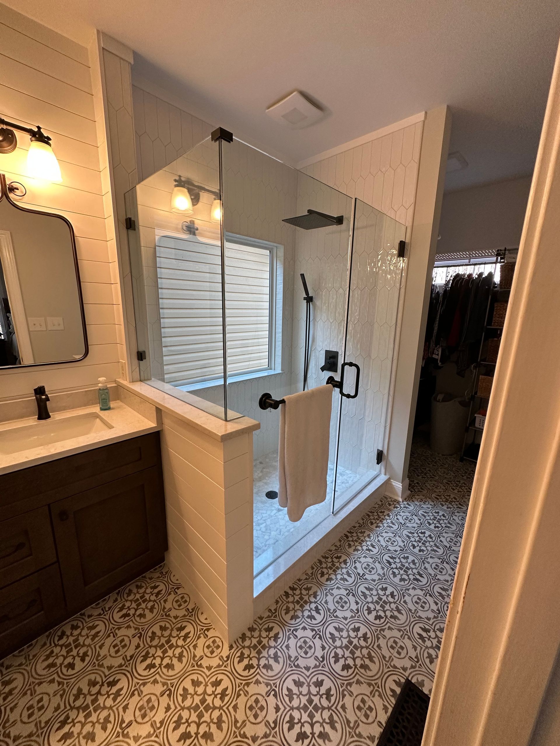 A bathroom with a walk in shower and a sink.
