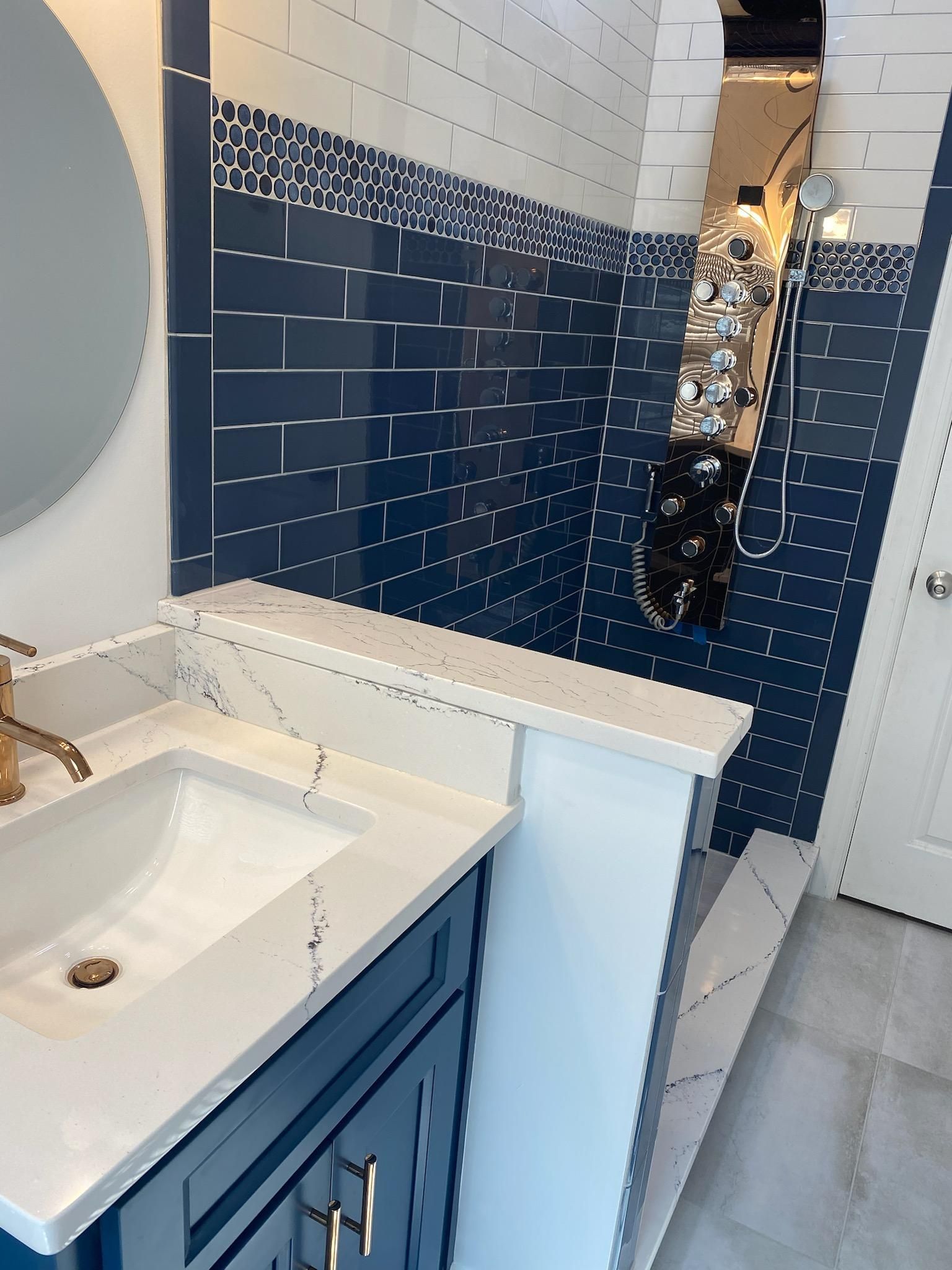 A bathroom with a sink , mirror and shower.
