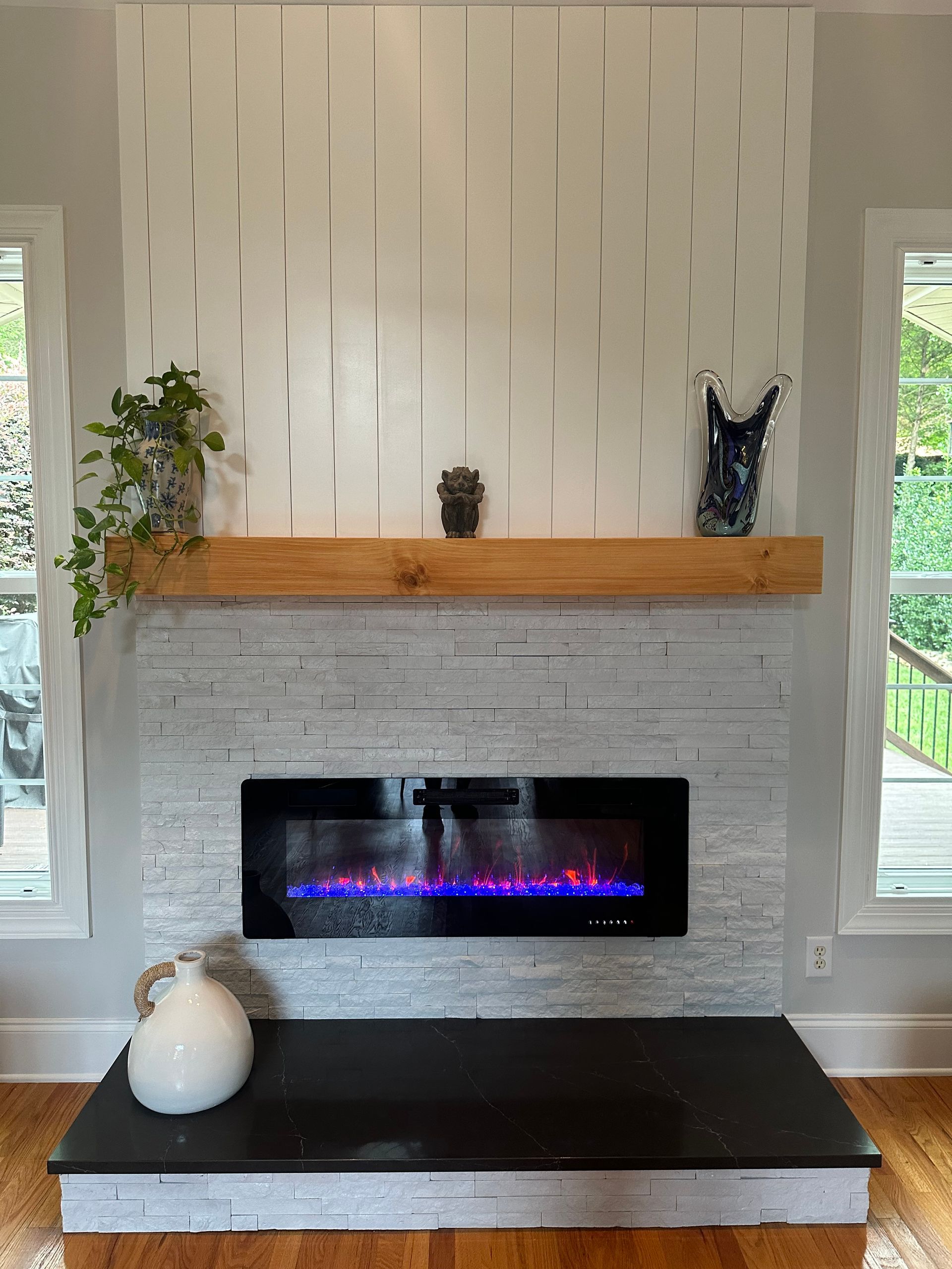A living room with a fireplace and a wooden mantle.