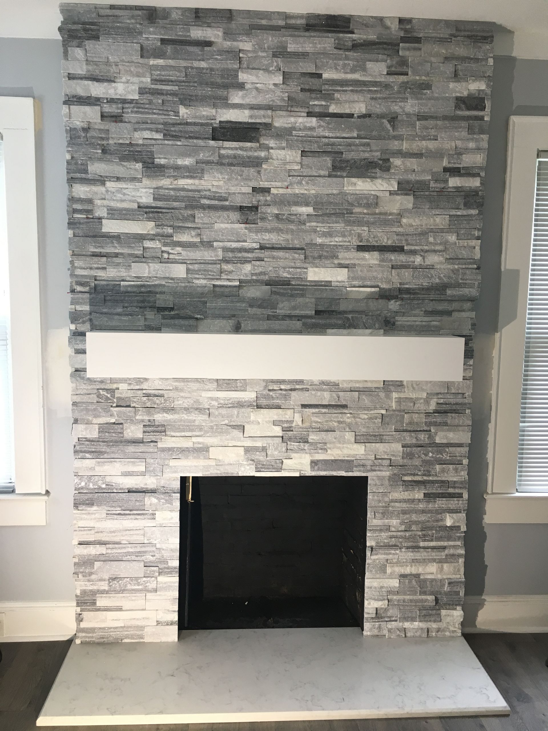 A fireplace in a living room with a stone wall