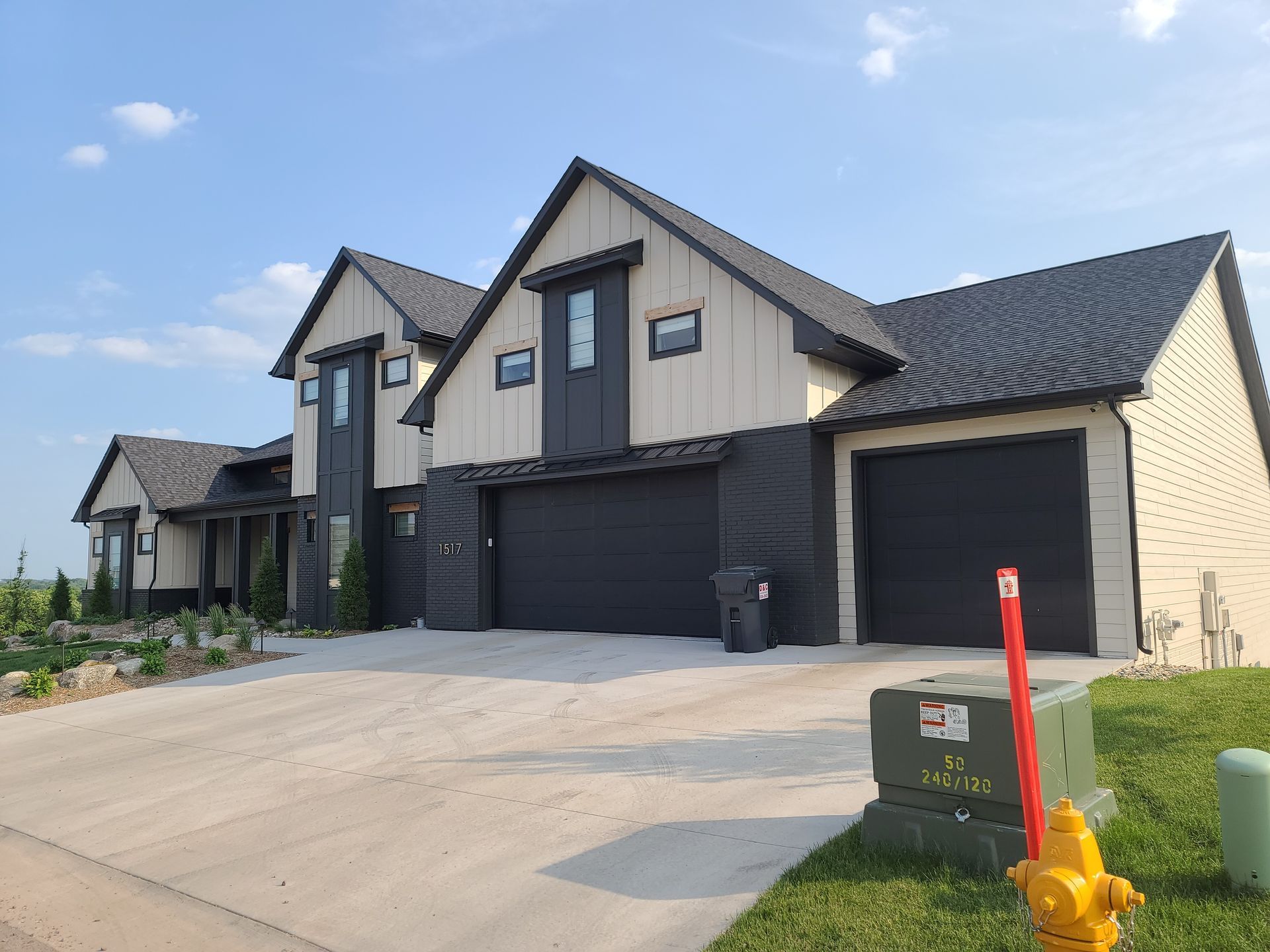 A large house with two garages and a fire hydrant in front of it.