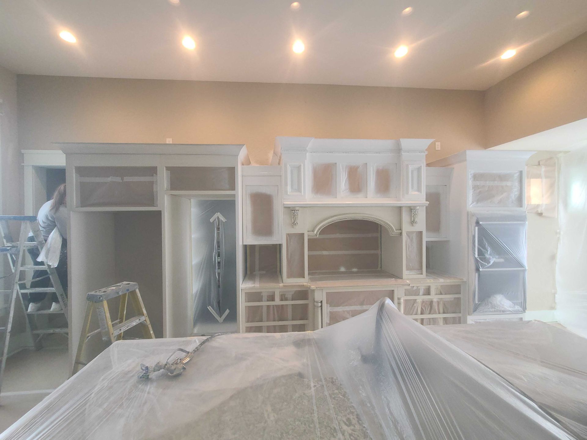 A room with a lot of cabinets and a ladder.