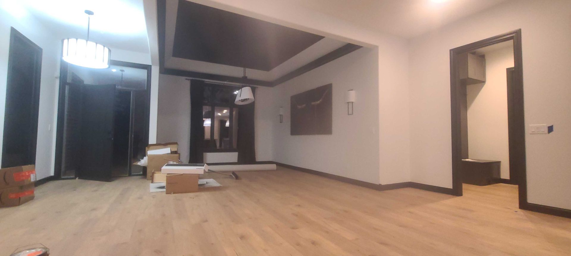 A large empty room with wooden floors and a black ceiling.