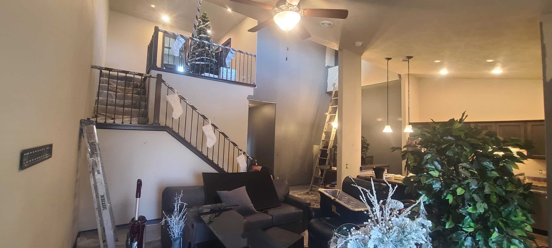 A living room with a staircase and a ceiling fan.