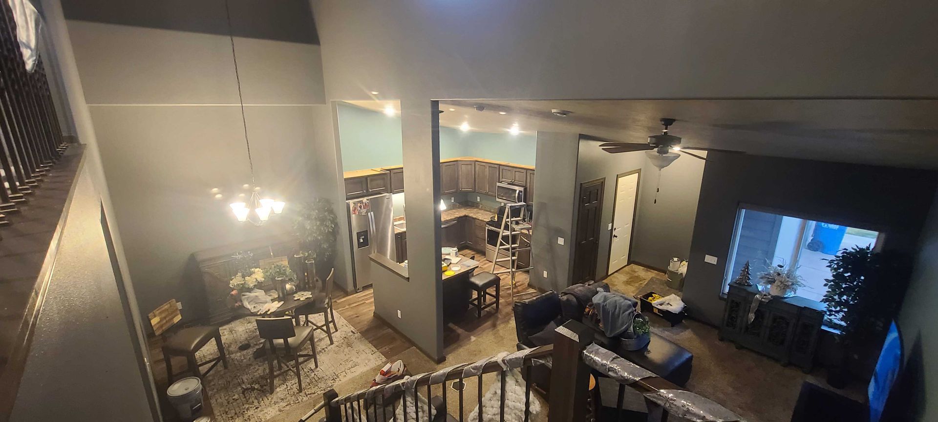 An aerial view of a living room and dining room from the second floor of a house.