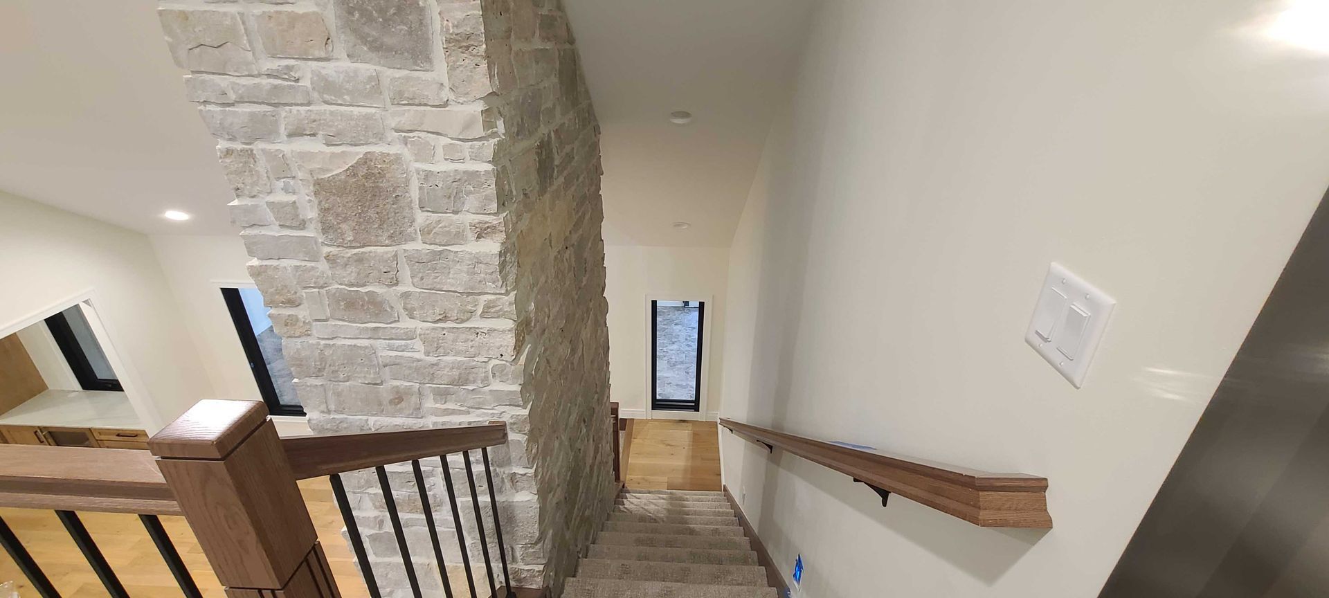 A hallway with stairs leading up to the second floor of a house.