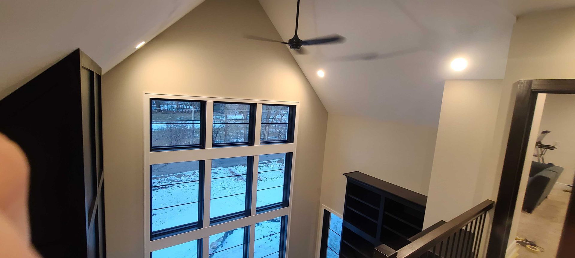 A room with a lot of windows and a ceiling fan.