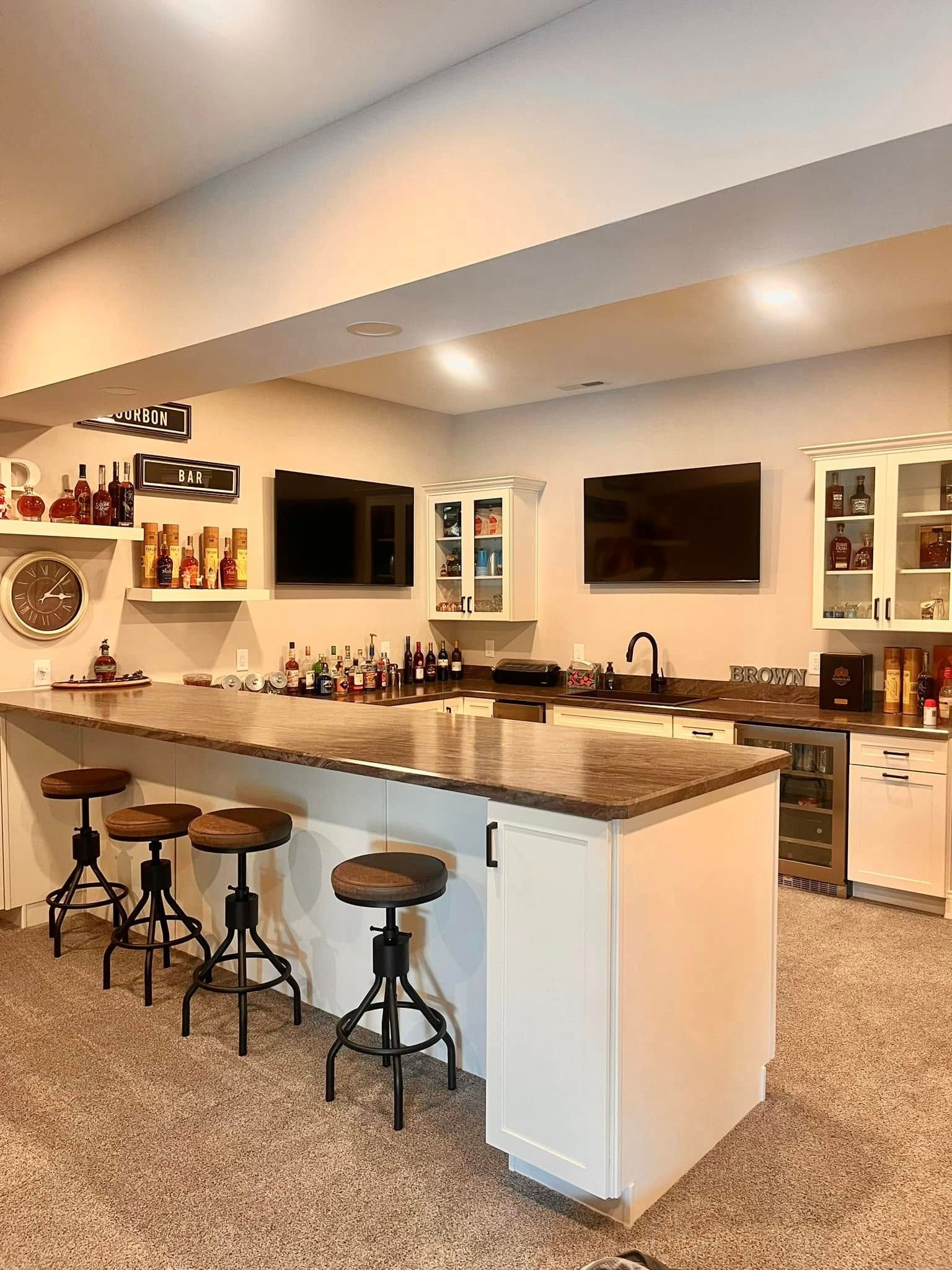 A kitchen with a bar and stools in it.