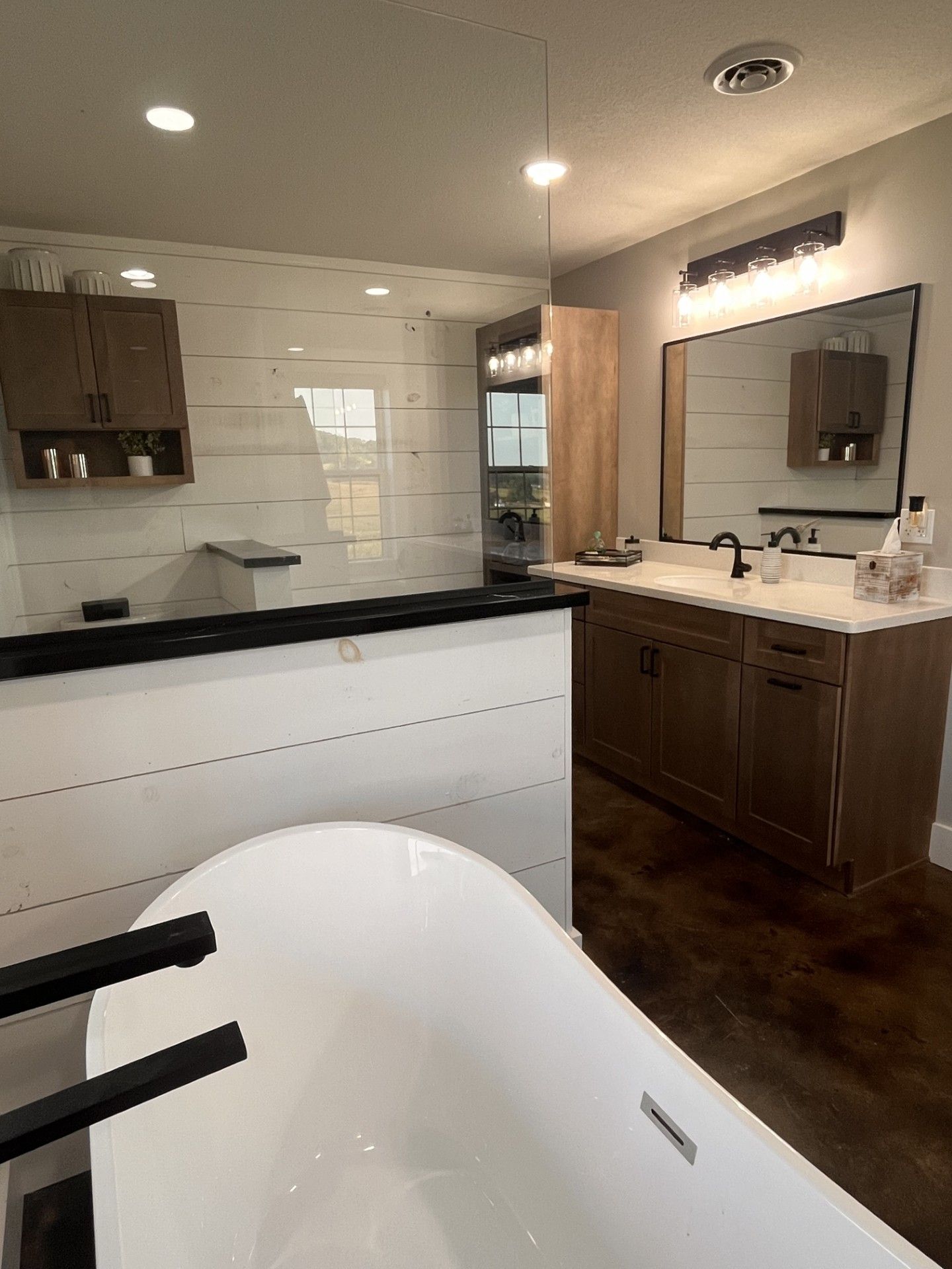 A bathroom with a bathtub , sink and mirror.