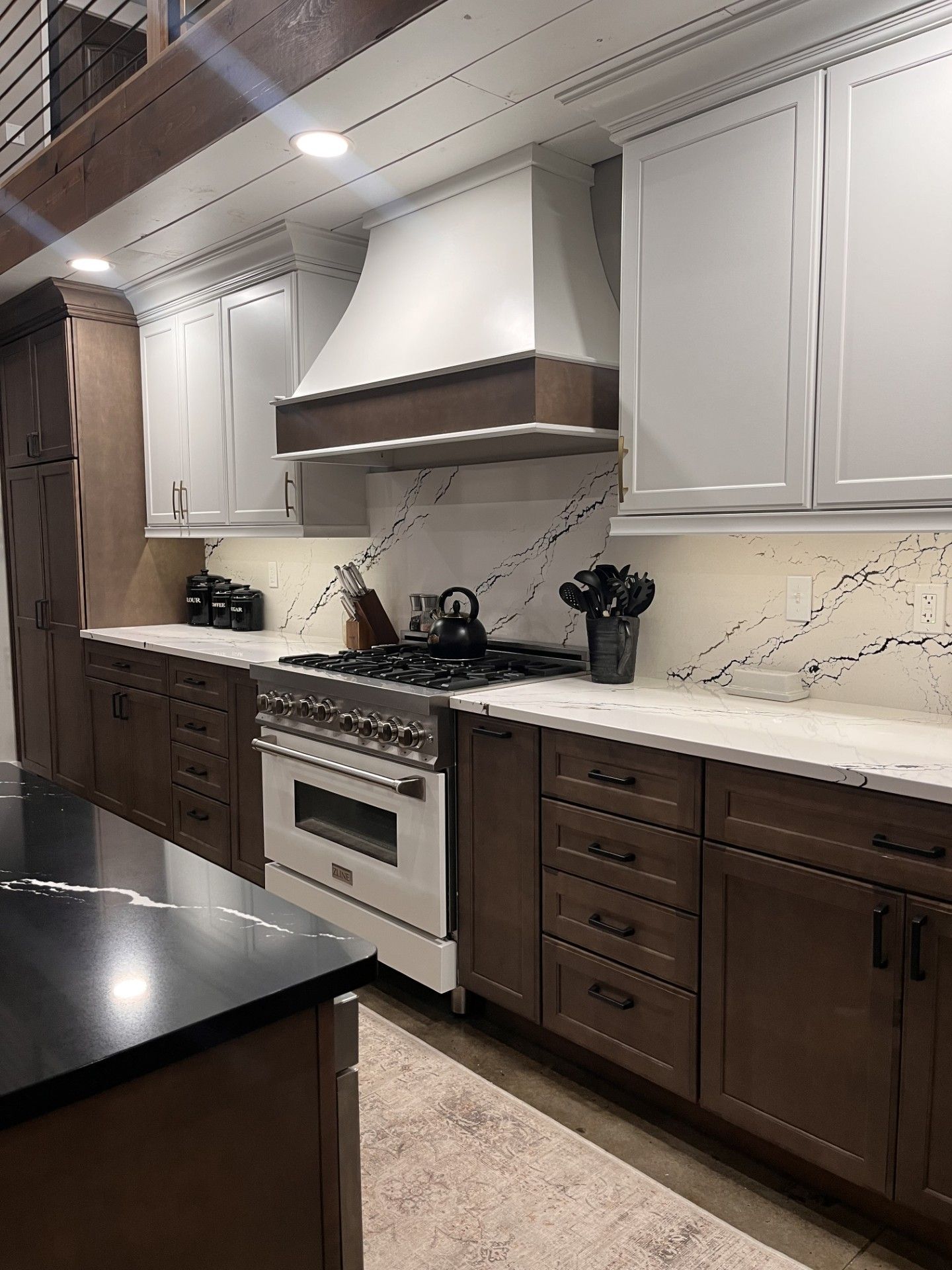 A kitchen with wooden cabinets , a stove , and a black counter top.