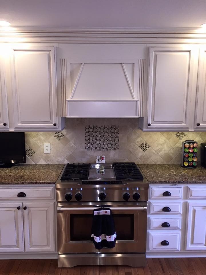 A kitchen with stainless steel appliances and white cabinets.