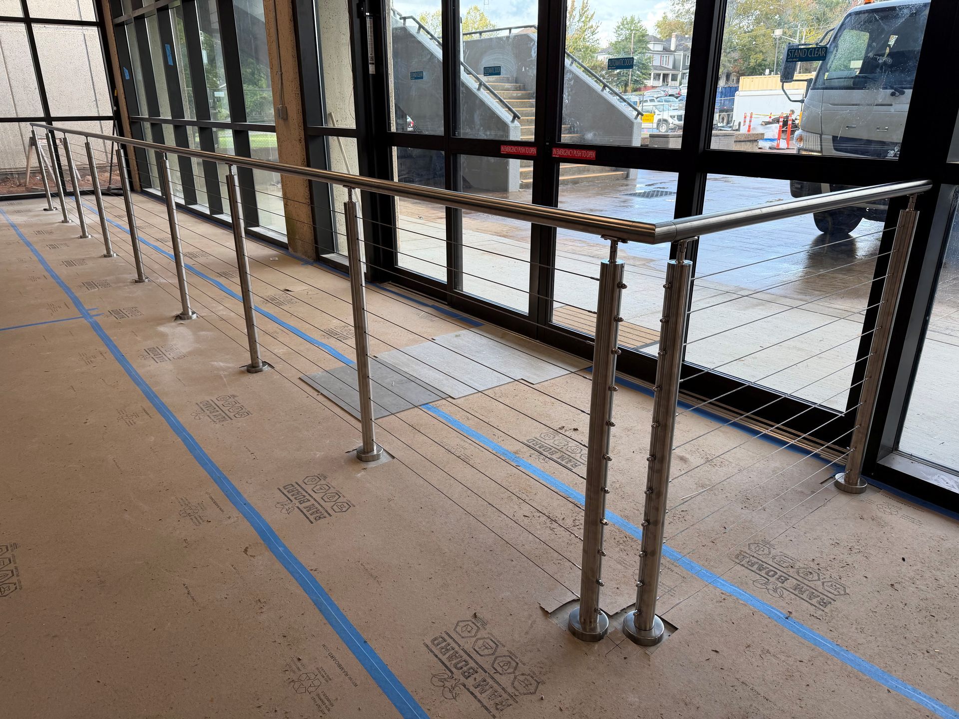 Roped-off sidewalk under construction beside a parked truck, with blue tape markings and metal barriers