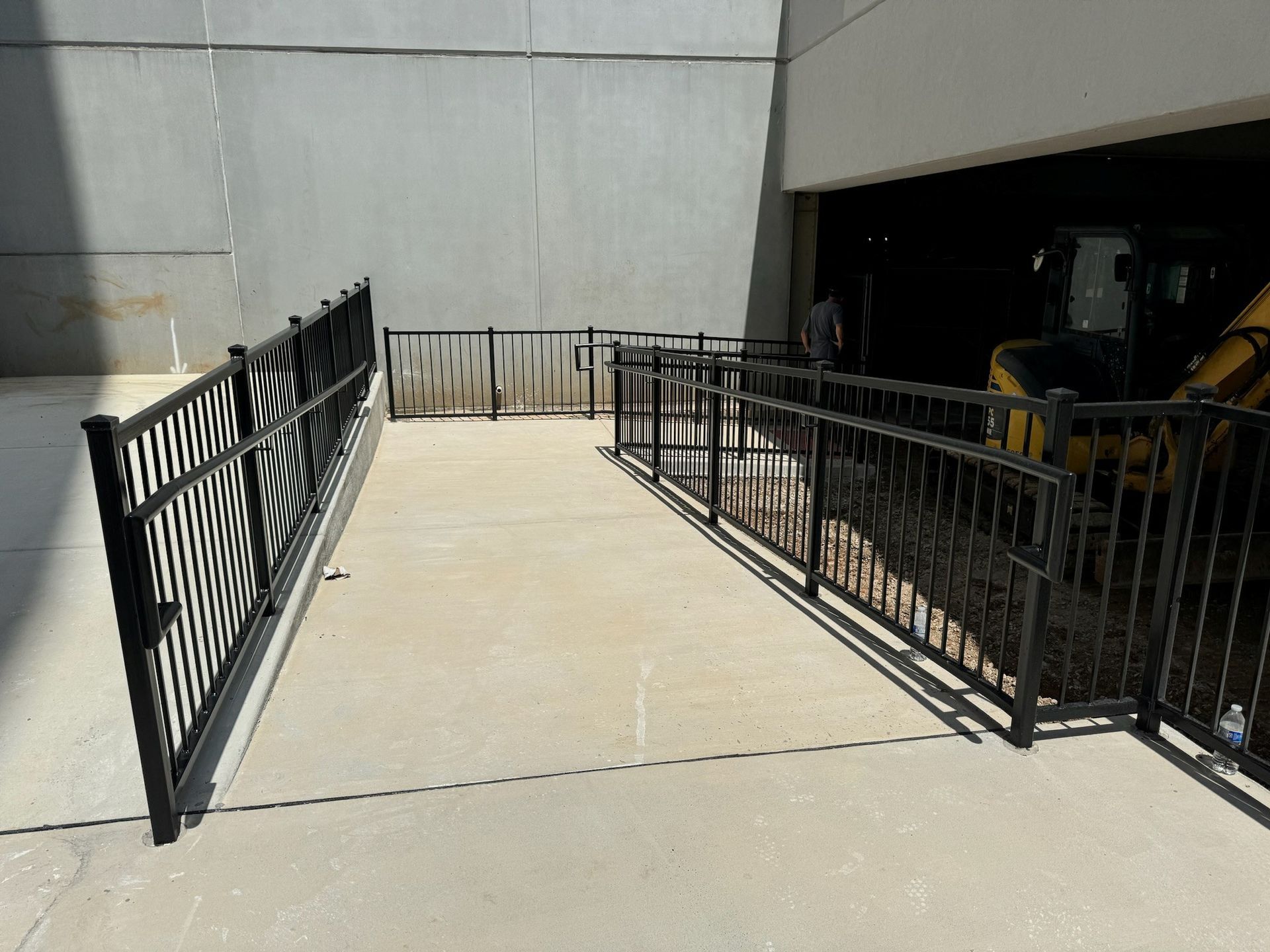 Accessible ramp with black railings leading to a building entrance